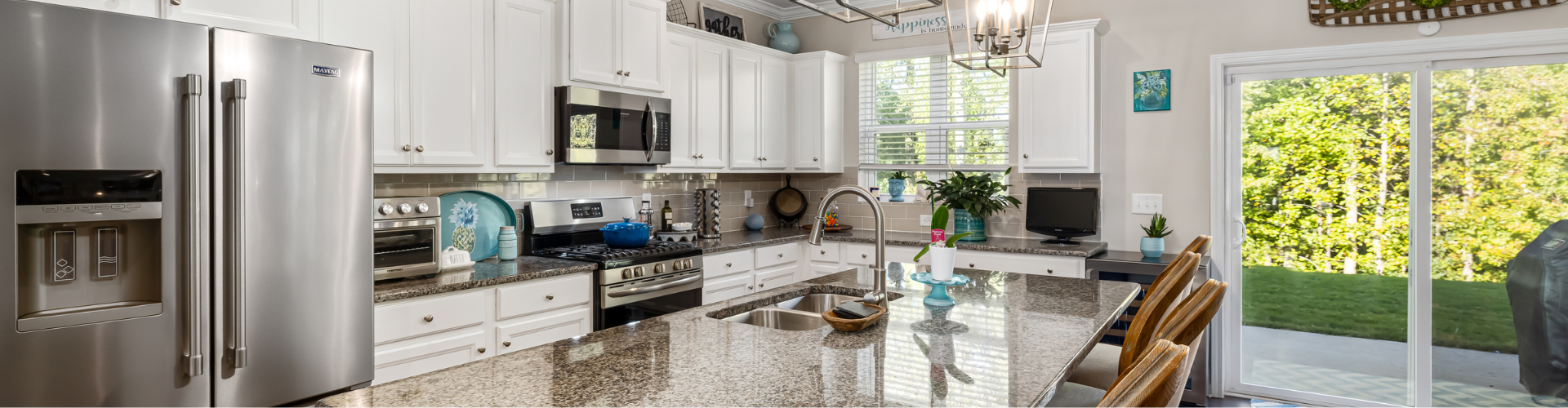 A kitchen with white cabinets.
