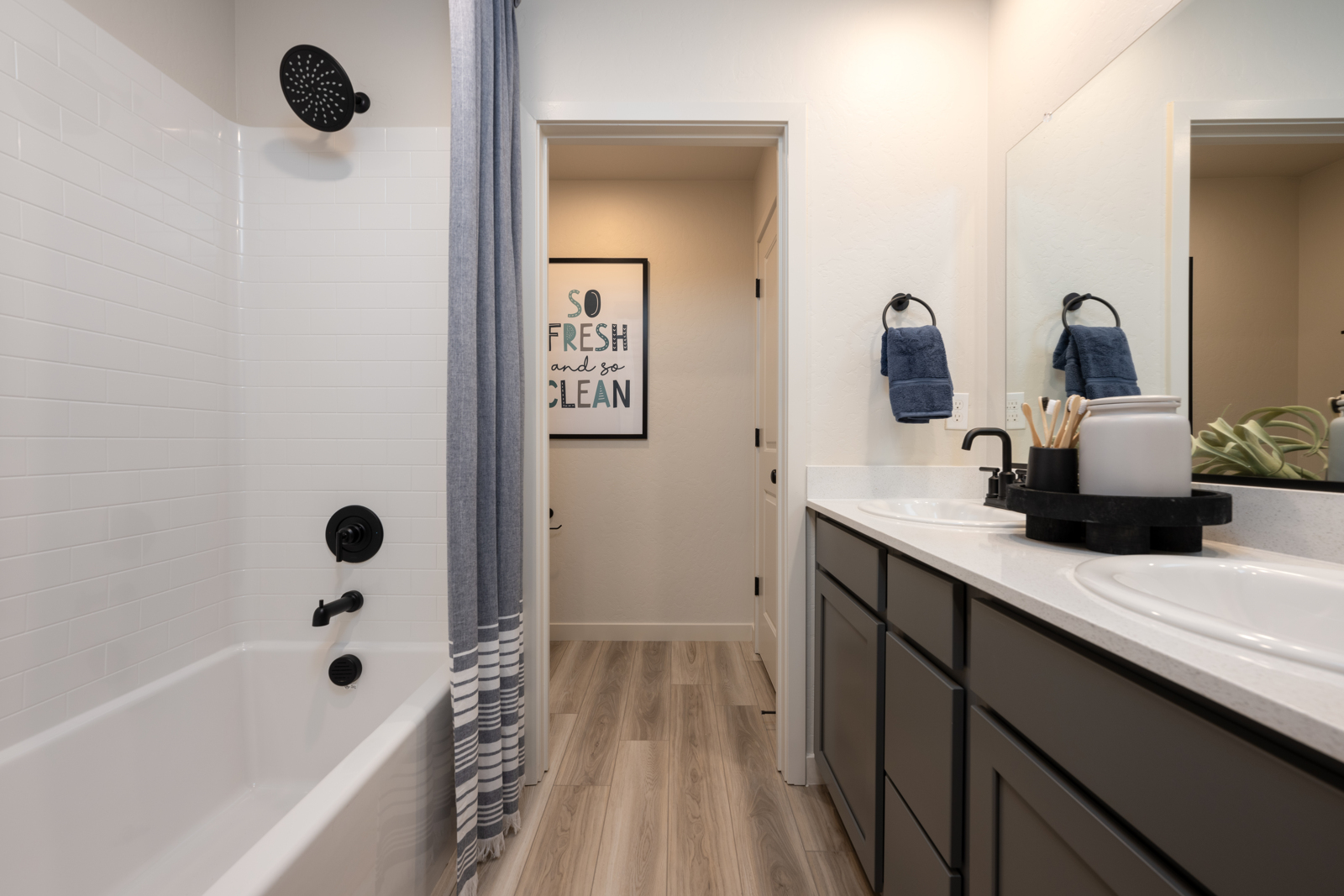 A bathroom with a tub sink and a mirror.