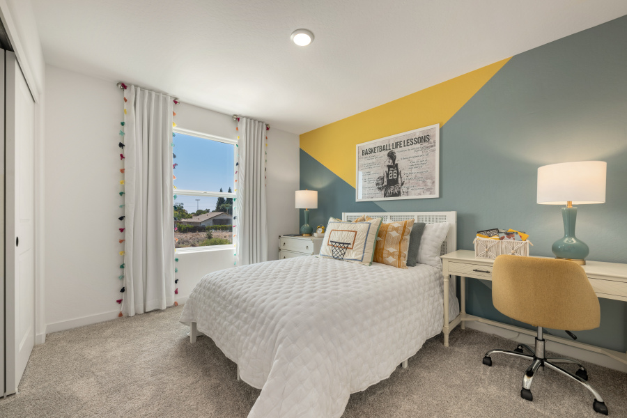 A bedroom with a bed and a desk.