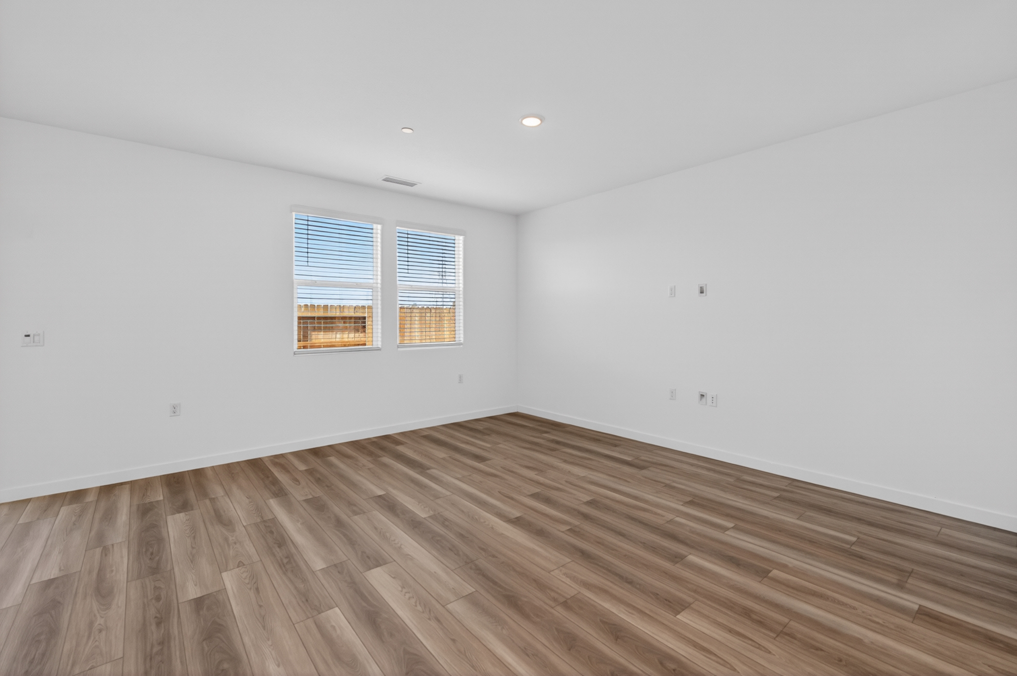A room with a wood floor and a window.