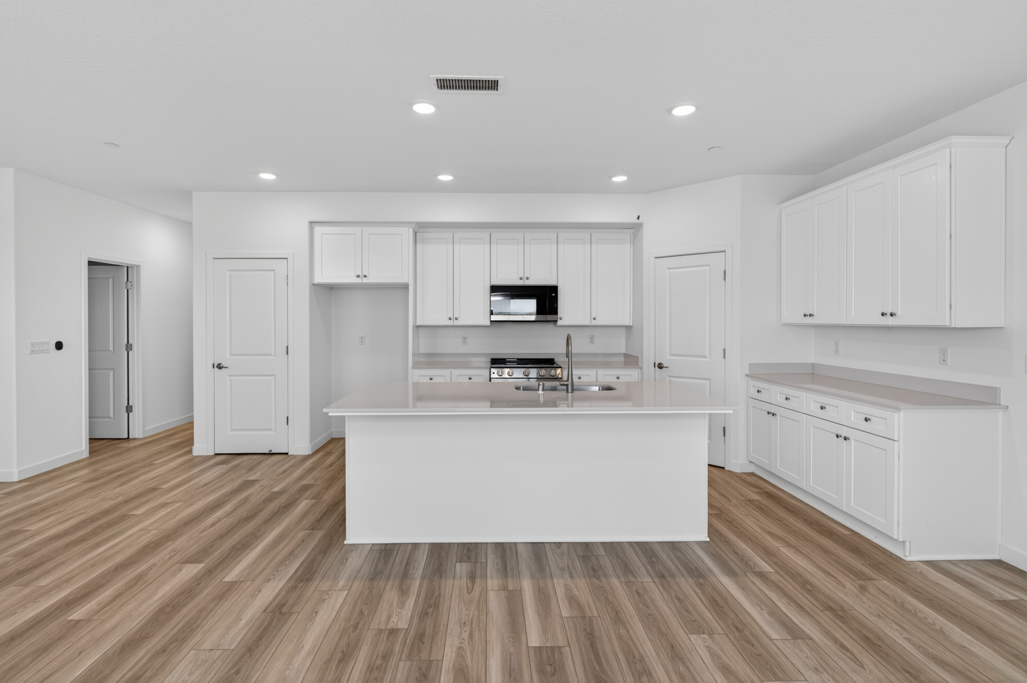 A kitchen with white cabinets.