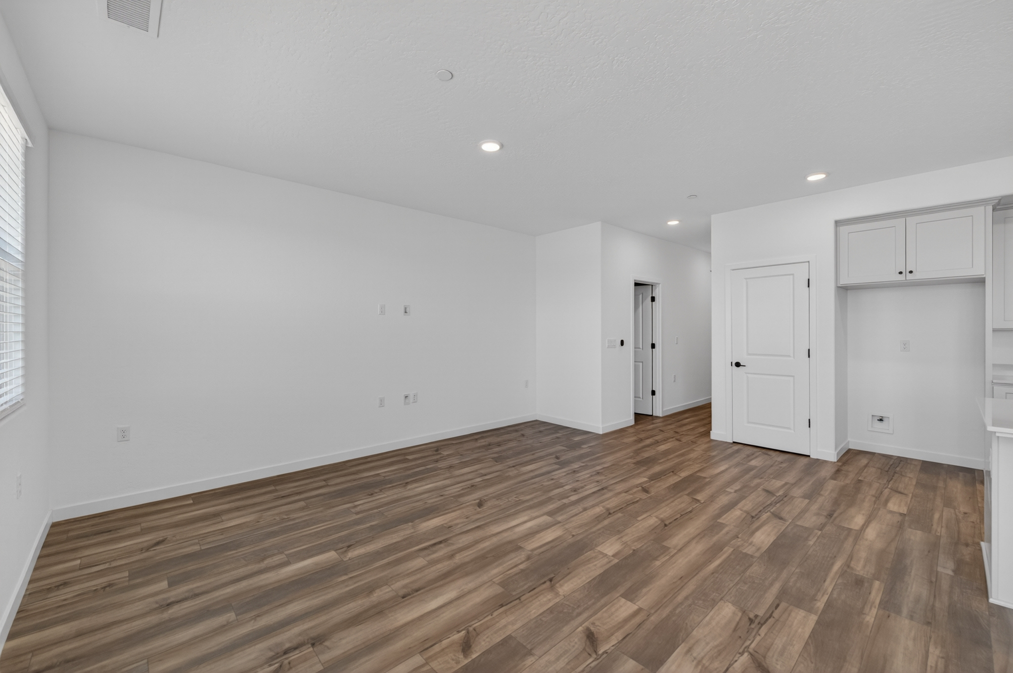 A room with white walls and wood floors.