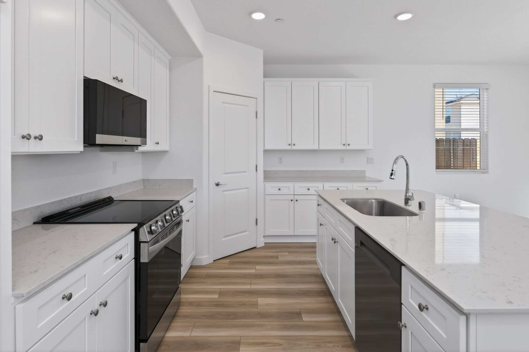 A kitchen with white cabinets.