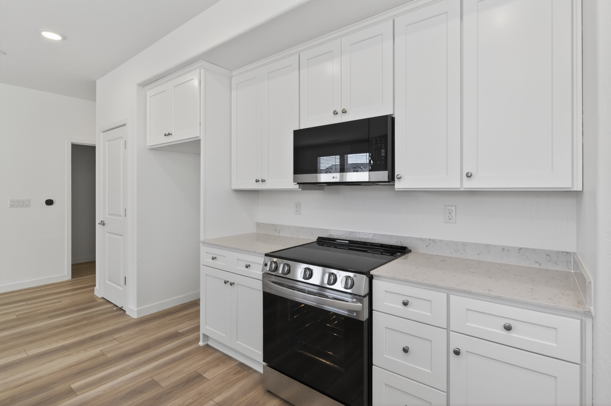 A kitchen with white cabinets.