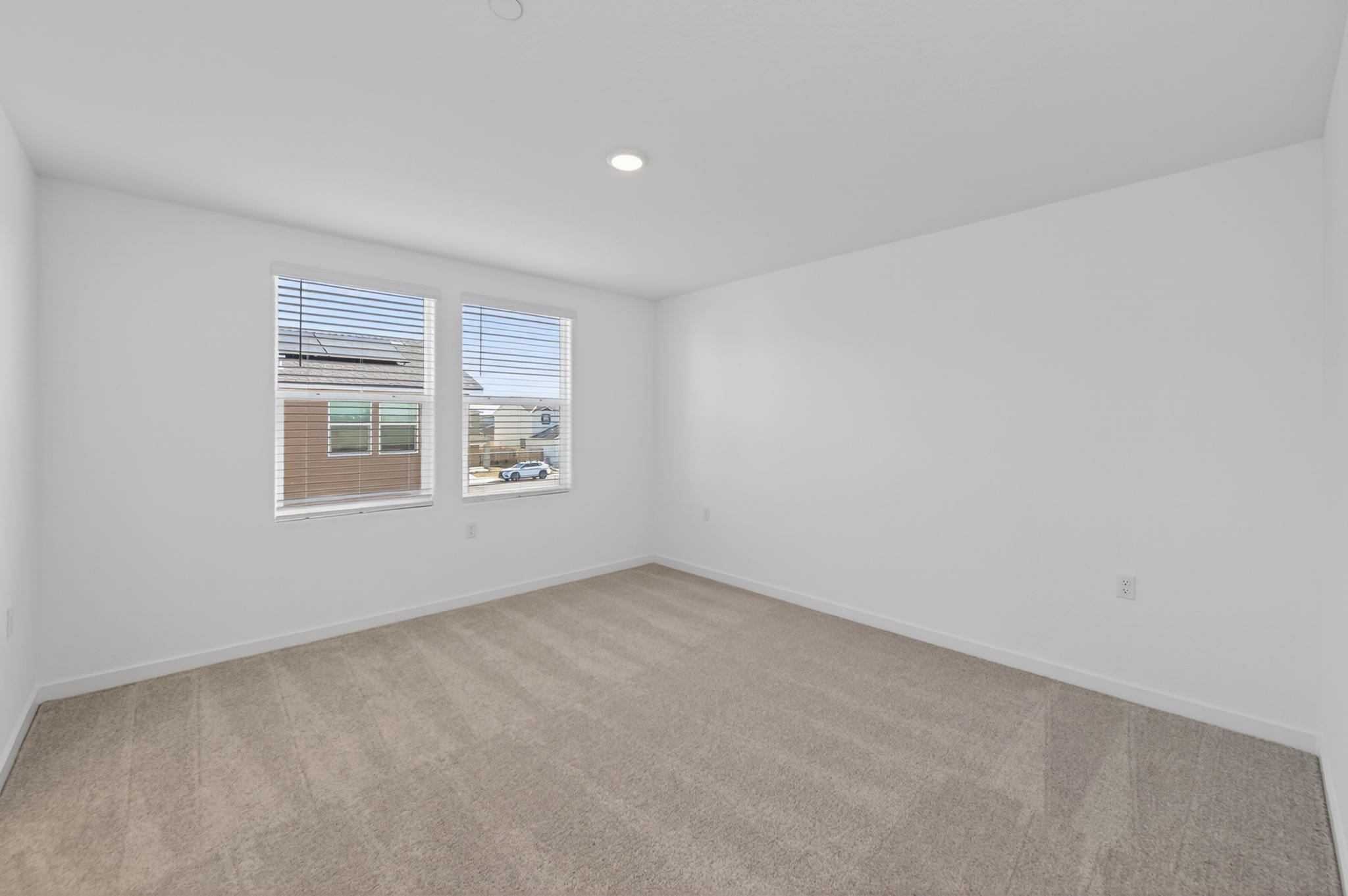 A room with a carpet and windows.