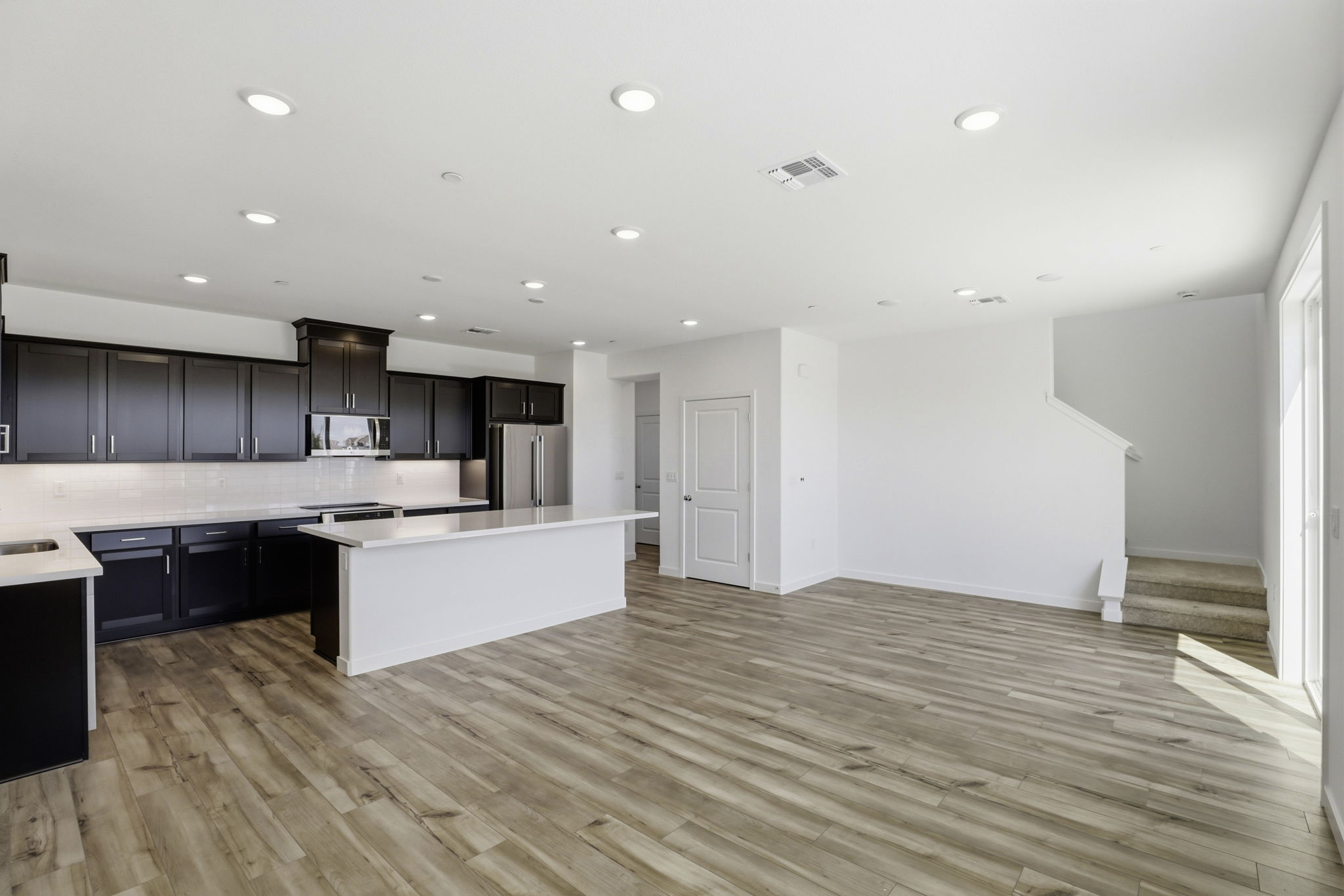 A large kitchen with black cabinets.
