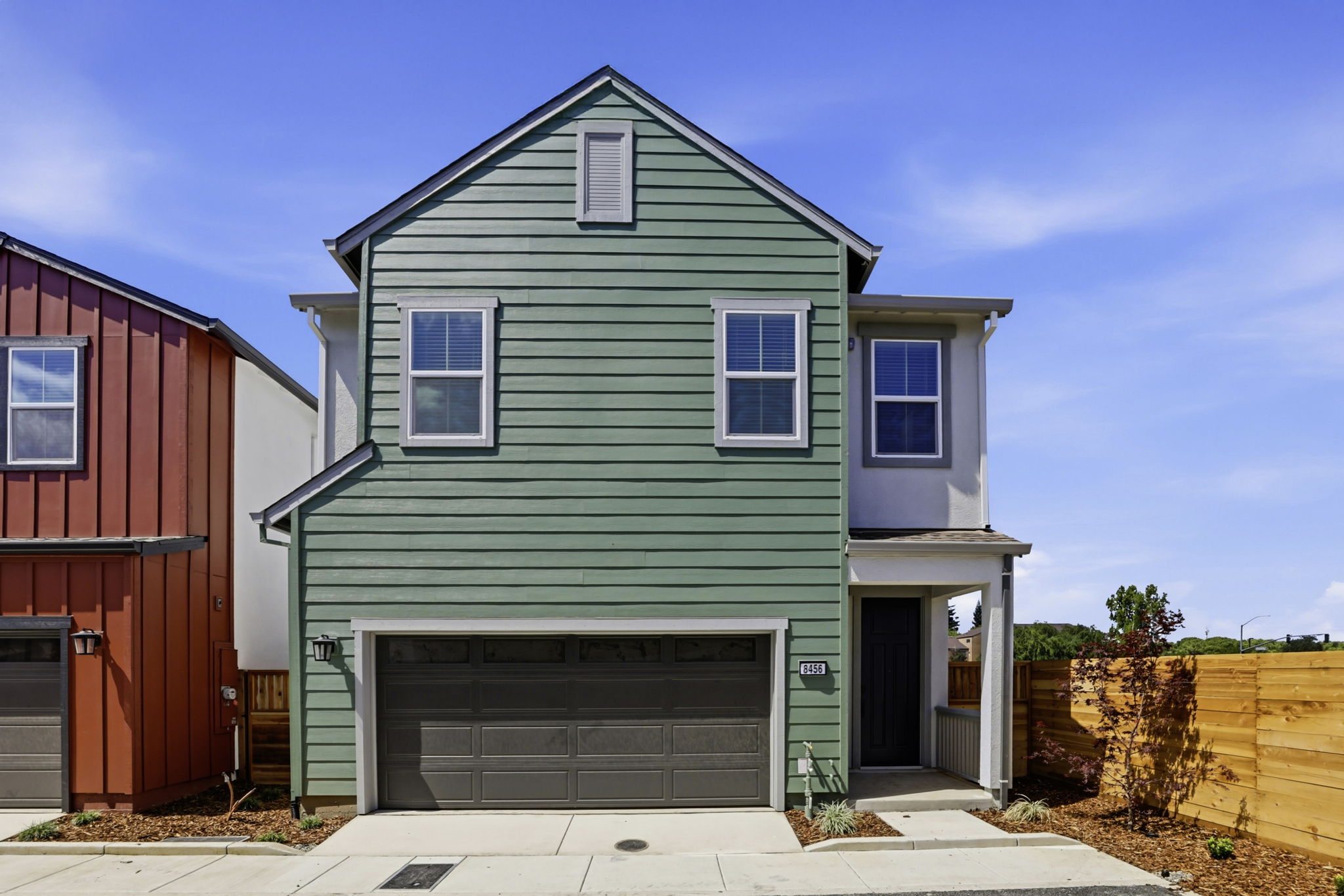 A green house with a garage.