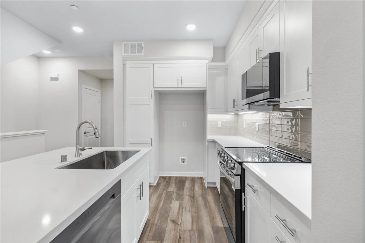 A kitchen with white cabinets.