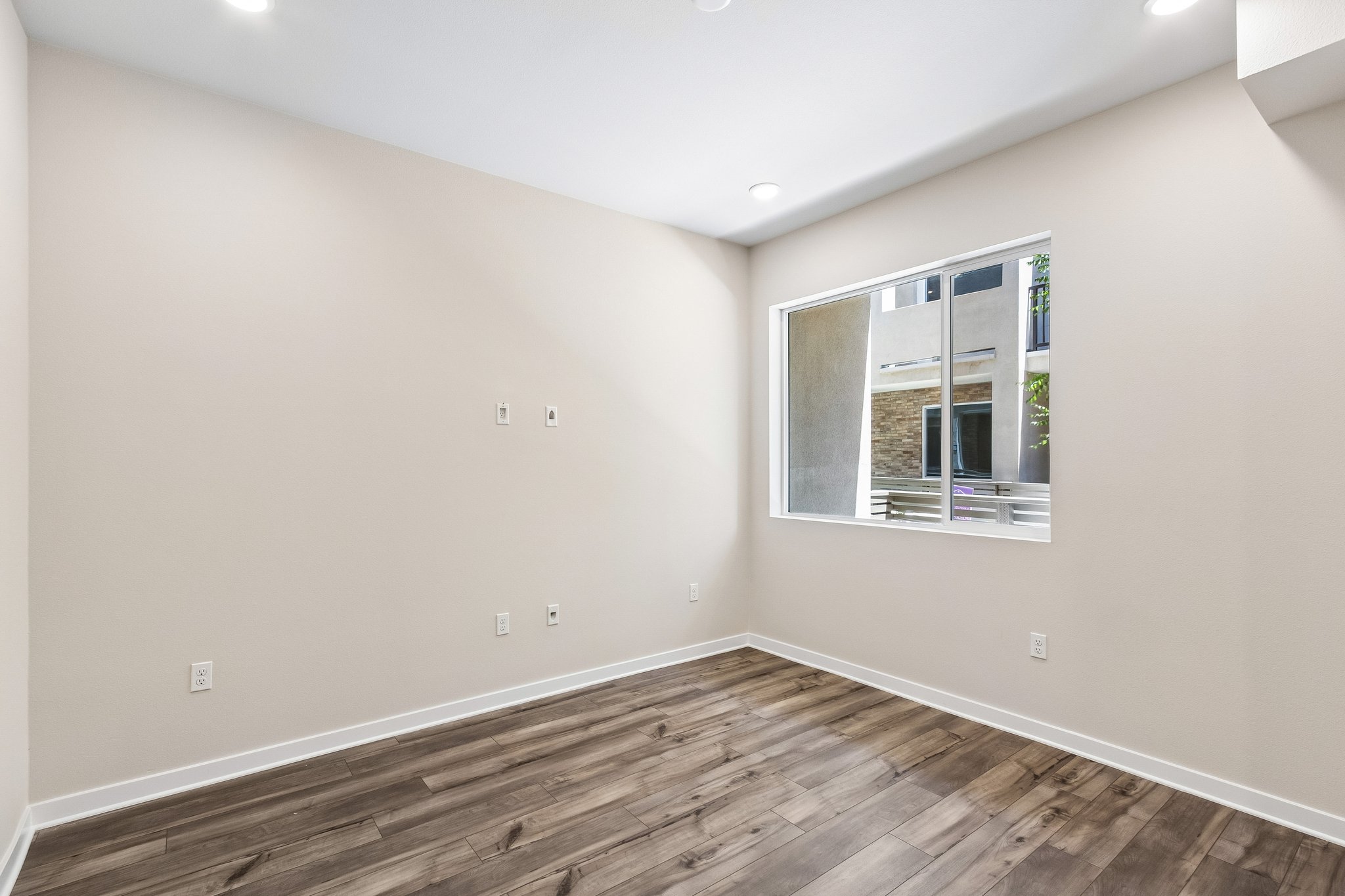 A room with a wood floor and a window.