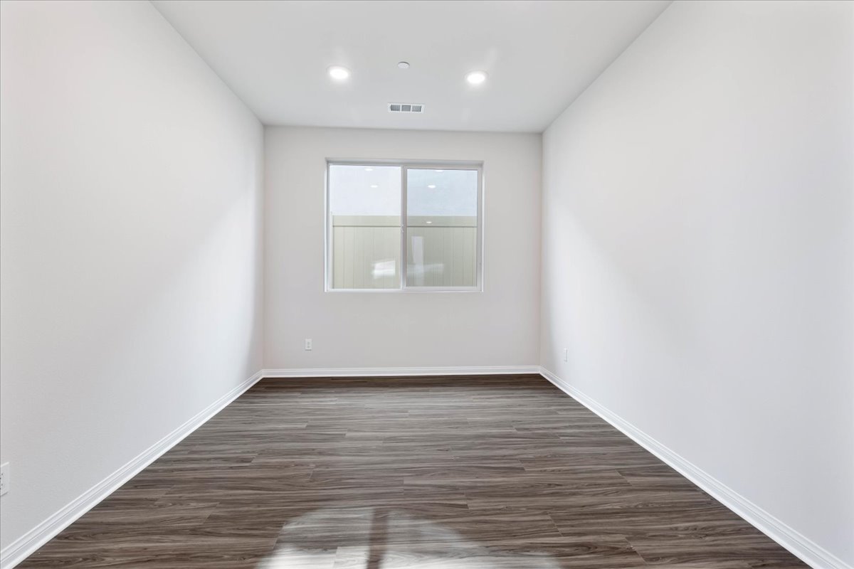A room with a wood floor and a window.