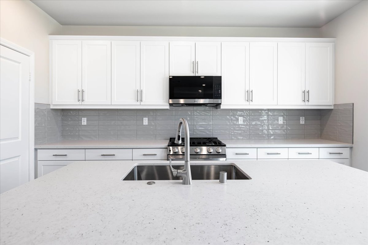 A kitchen with white cabinets.