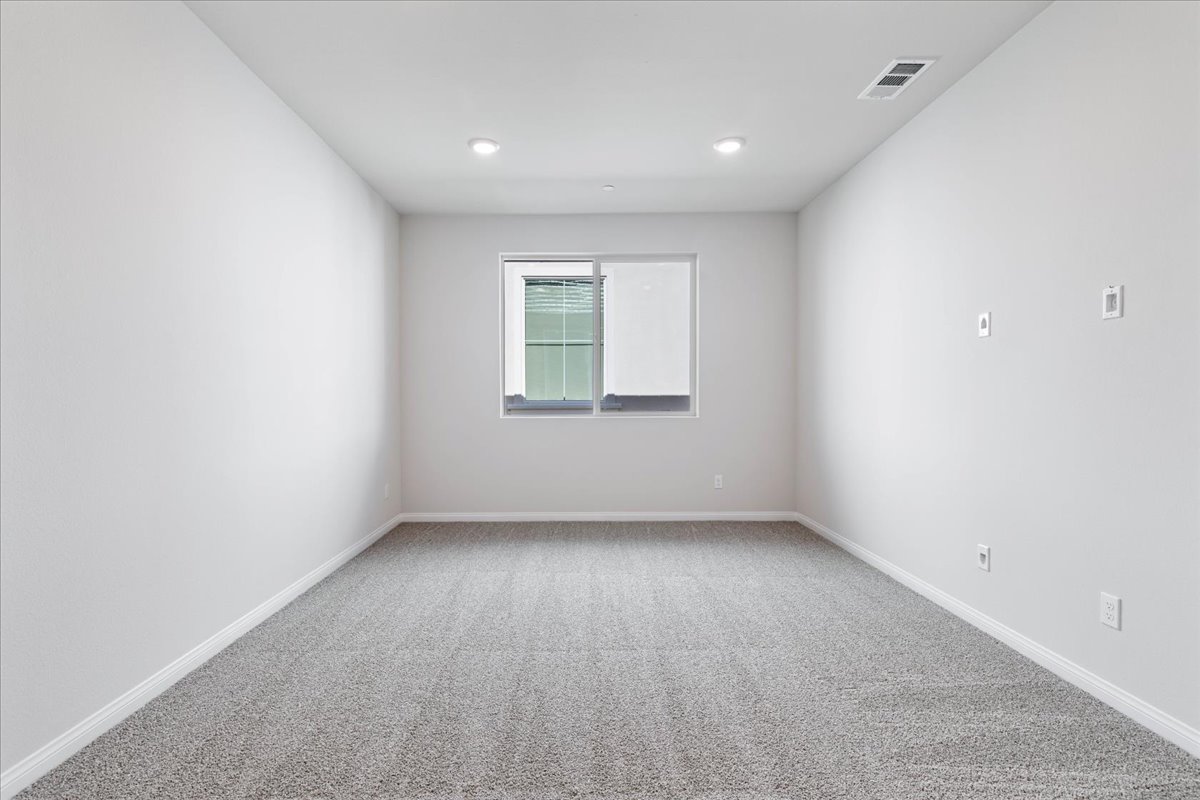 A room with a window and a carpet.