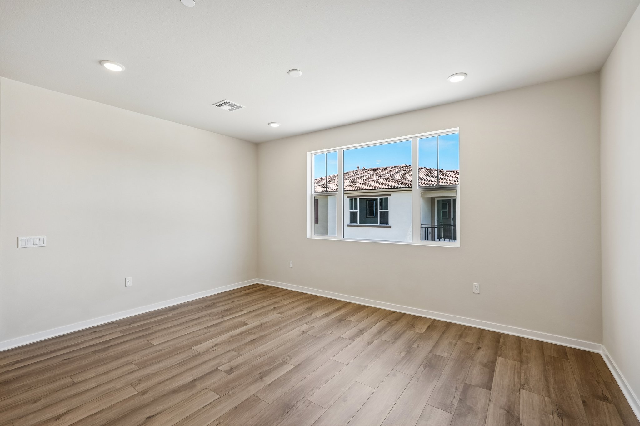 A room with a wood floor and a window.