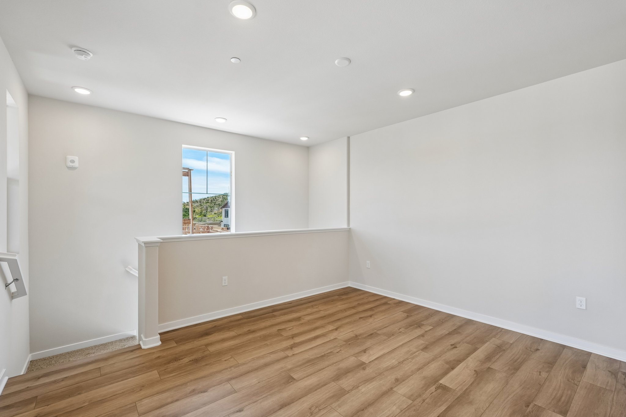 A room with a wood floor and a window.