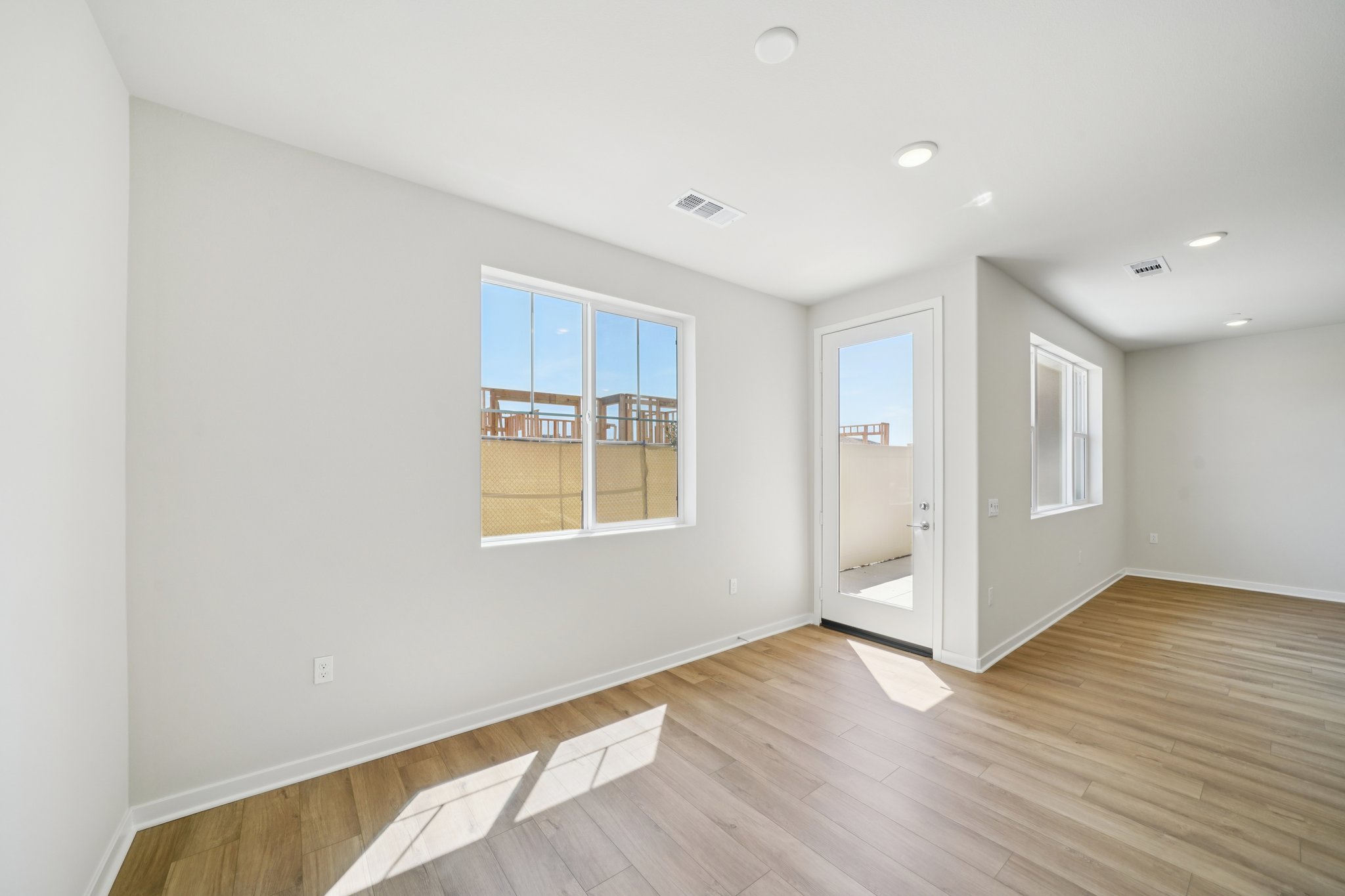 A room with a wood floor and a wood floor with a window.