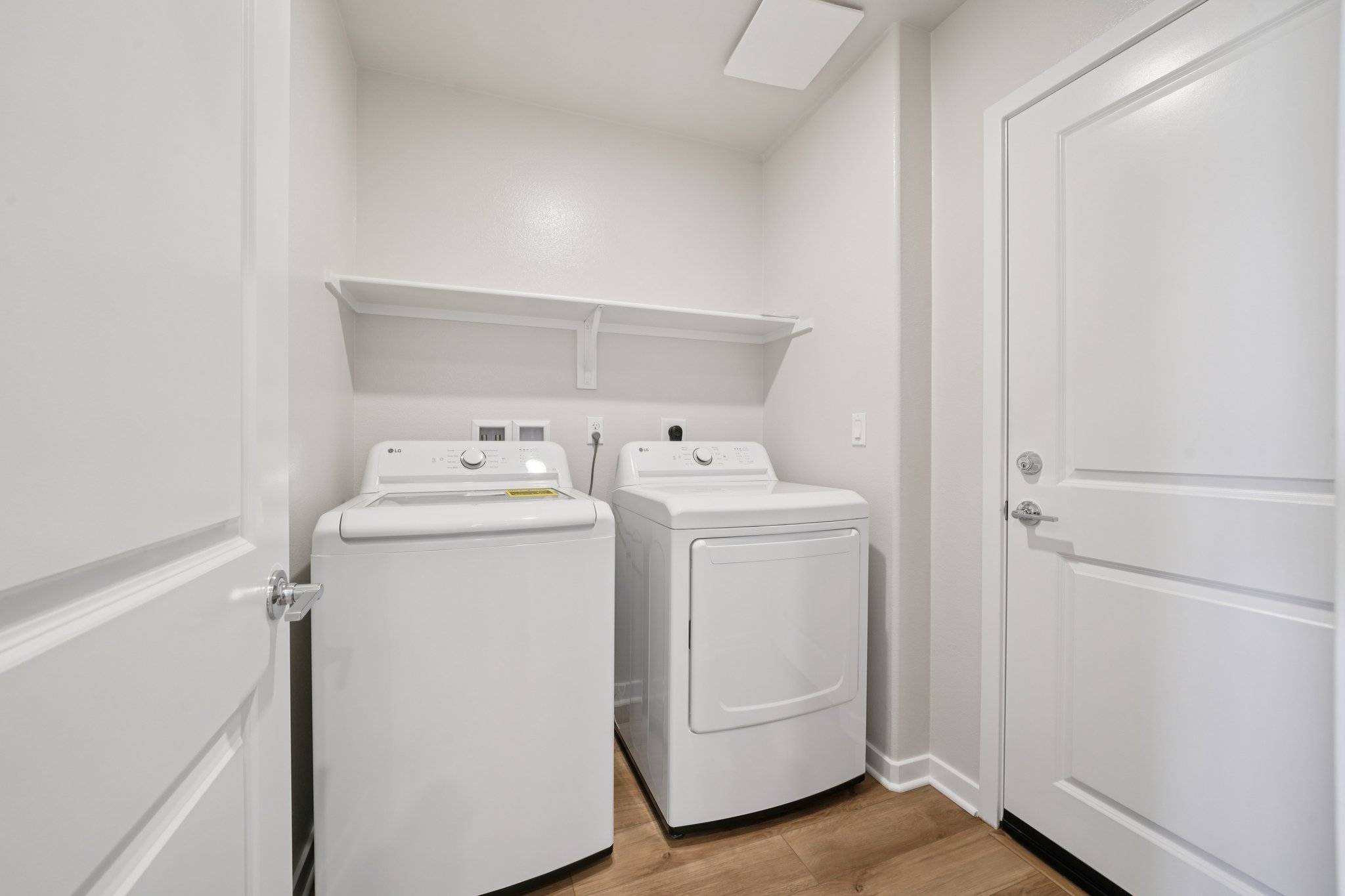 A laundry room with white cabinets.