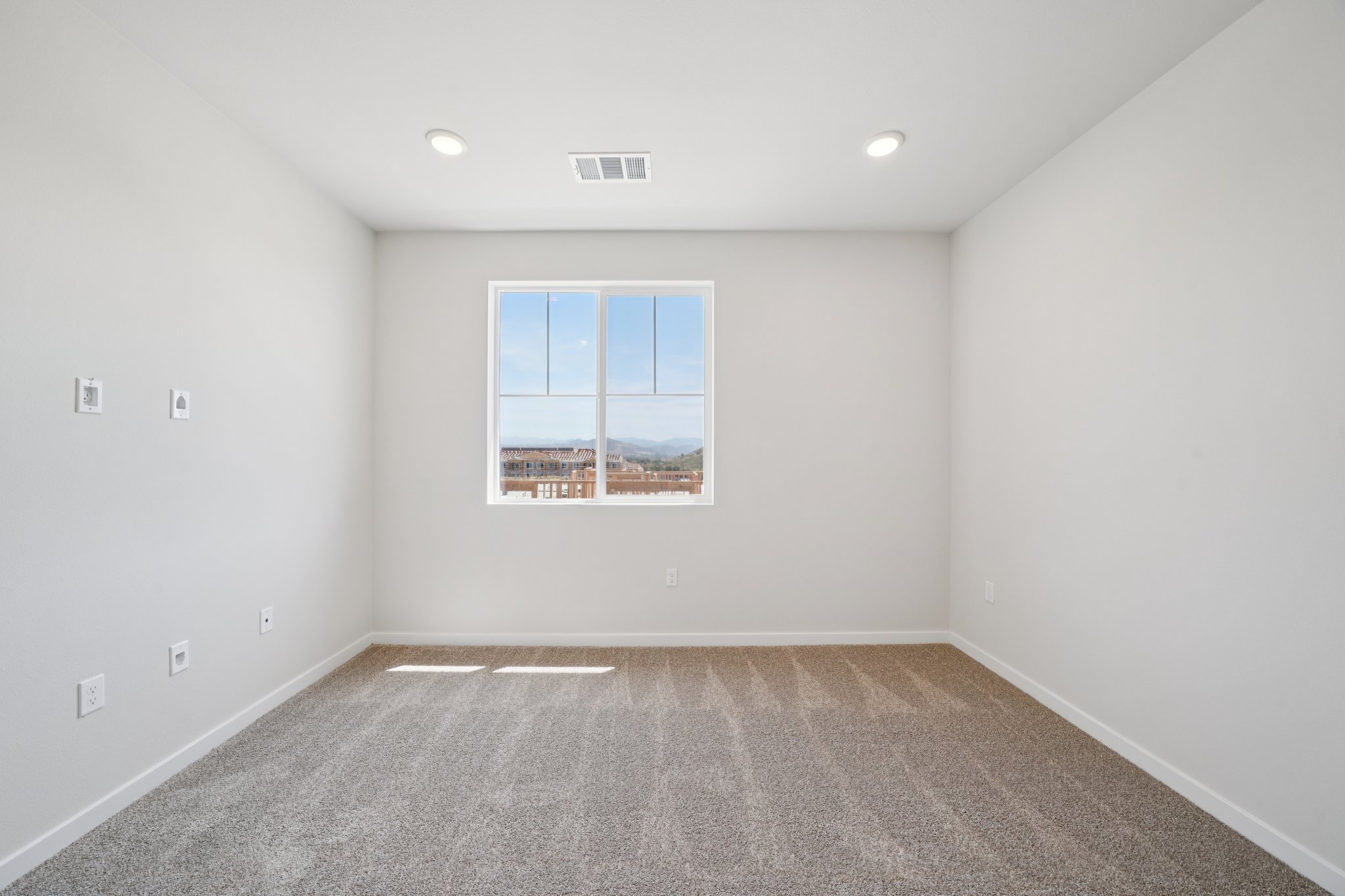 A room with a window and a carpet.