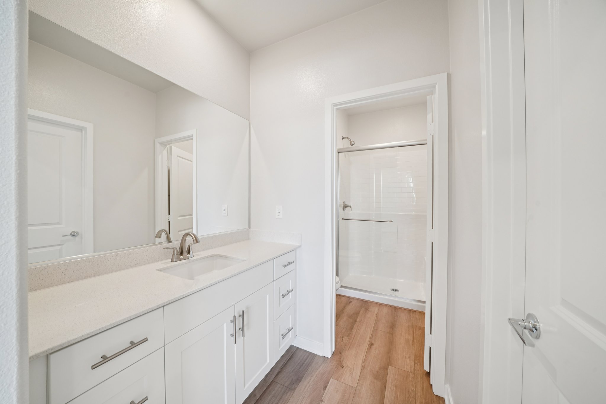 A bathroom with white cabinets.