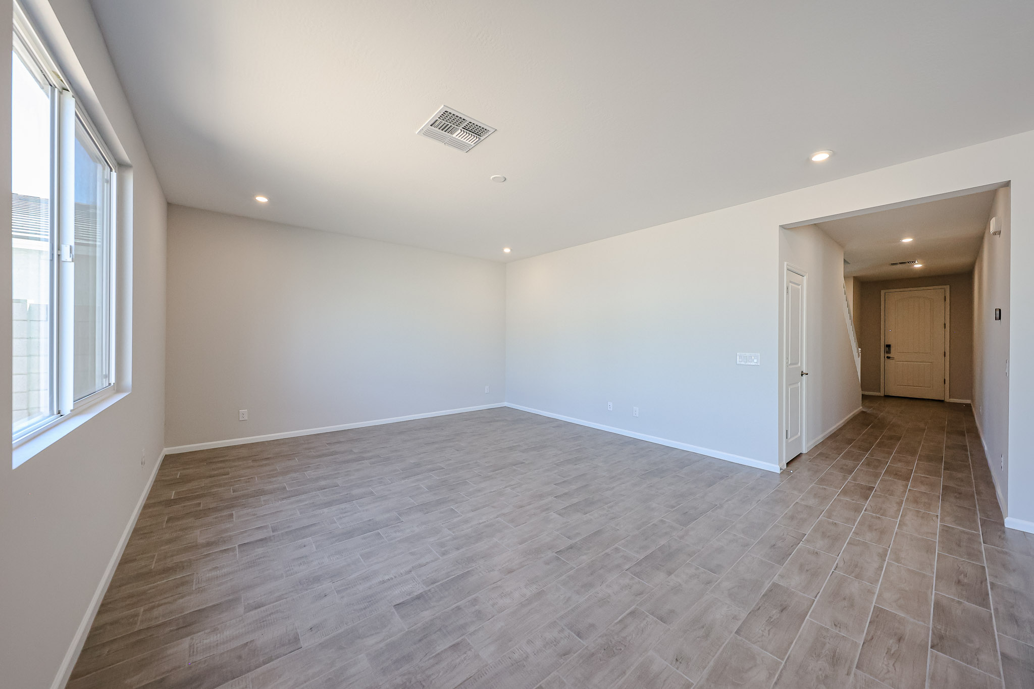 A room with a wood floor and windows.