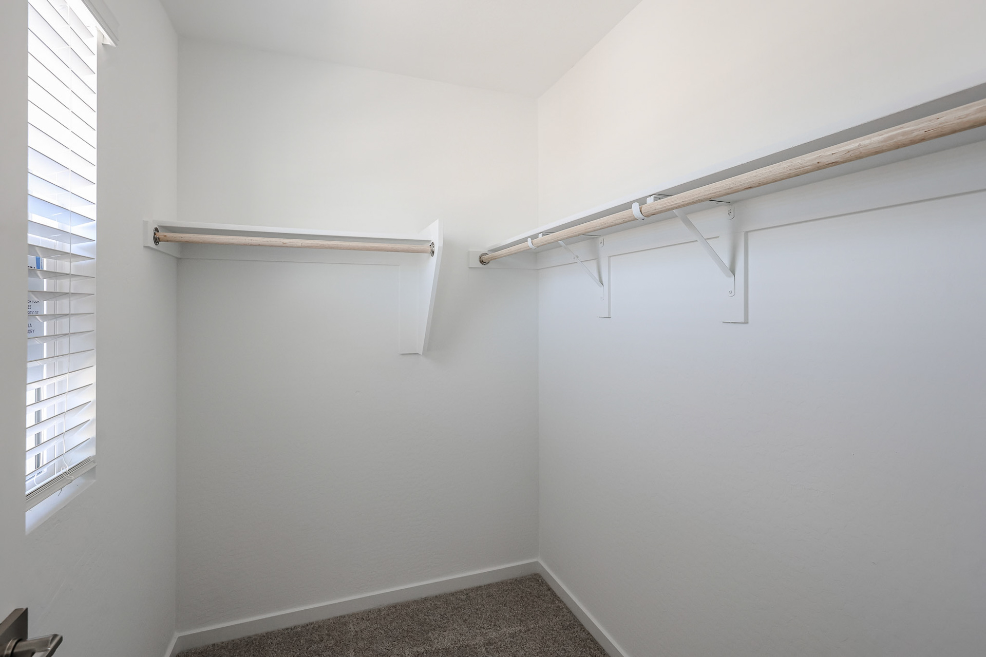 A white wall with a metal bar.