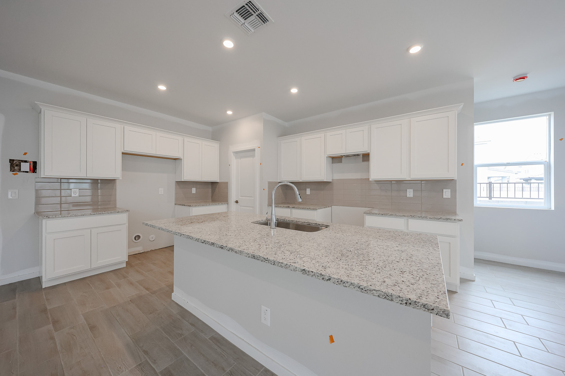 A kitchen with white cabinets.