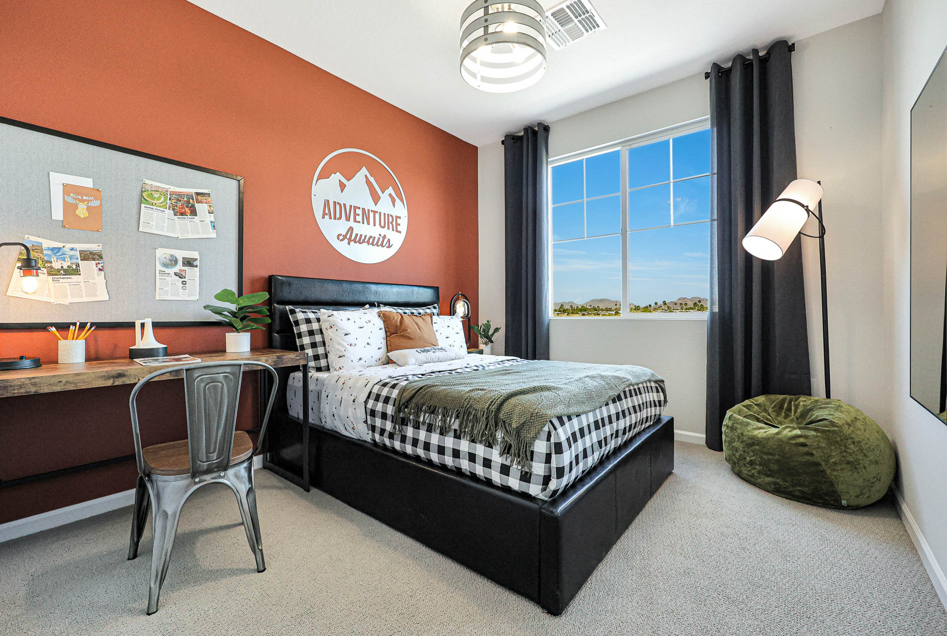 A bedroom with a bed desk and a chair.