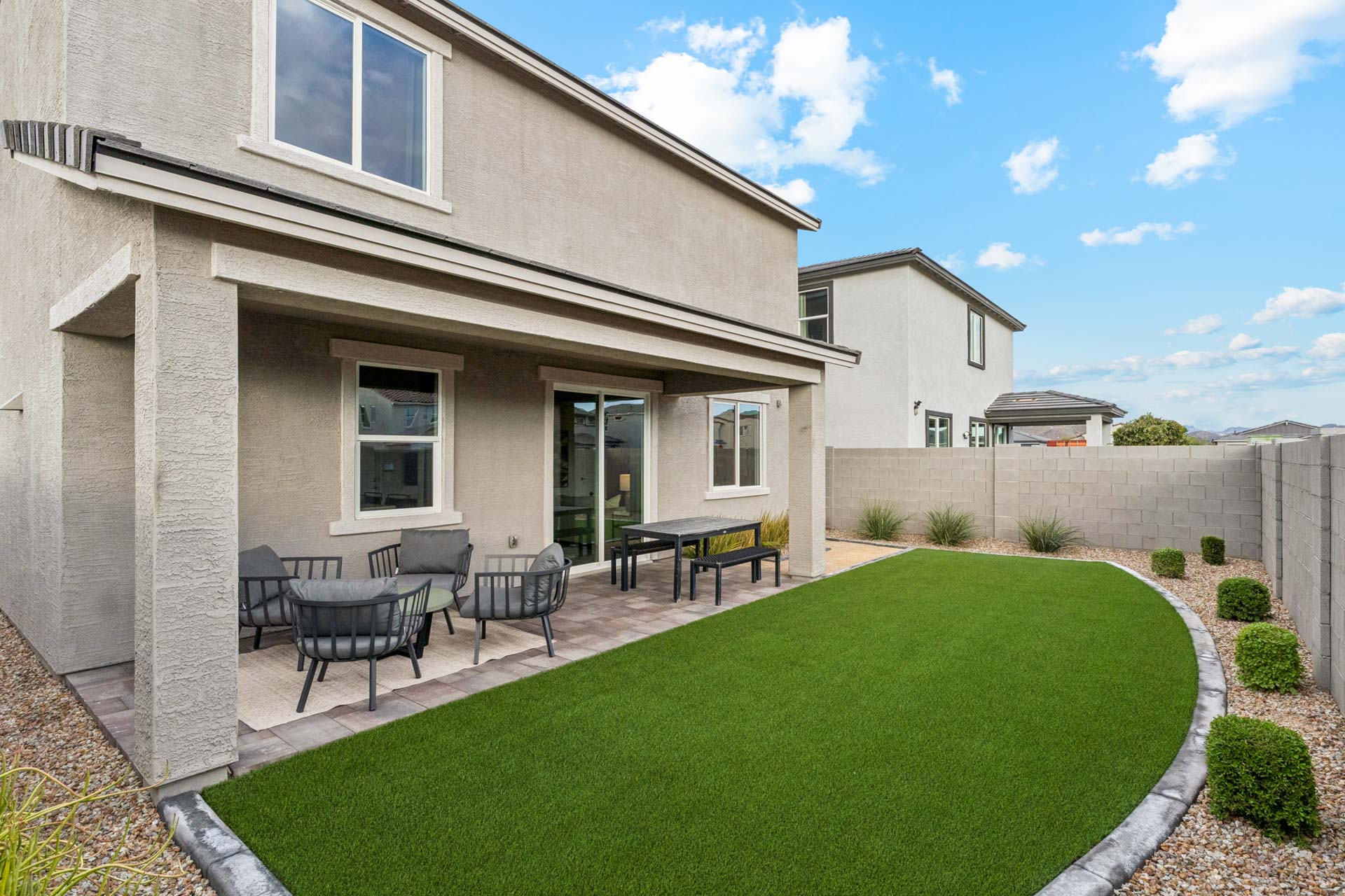 A backyard with a pool and chairs.