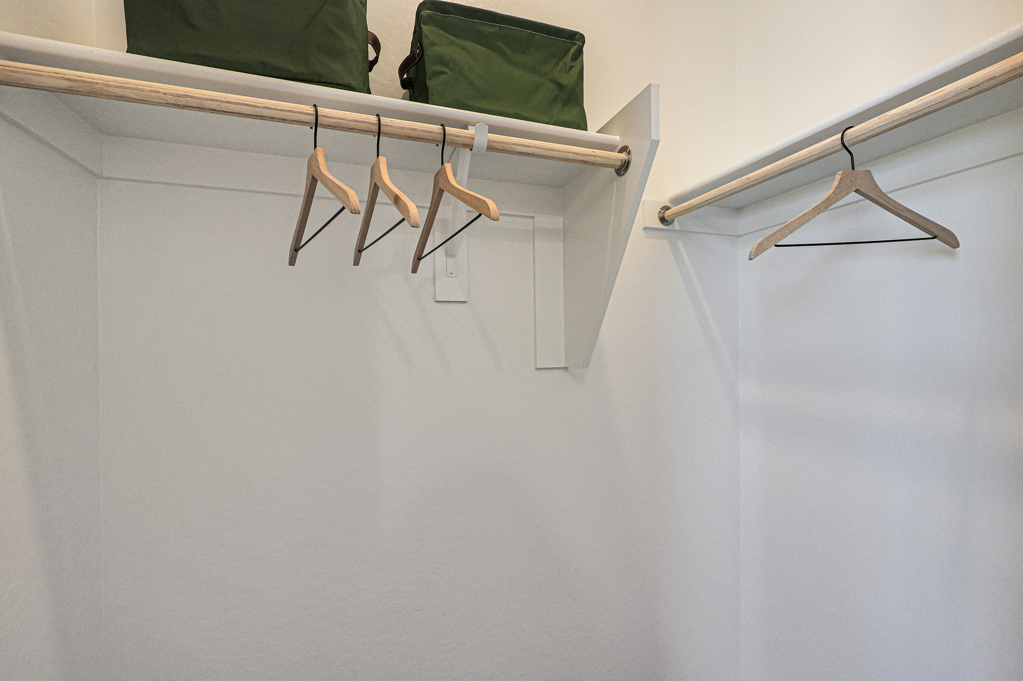 A white wall with a green pillow and a green pillow.