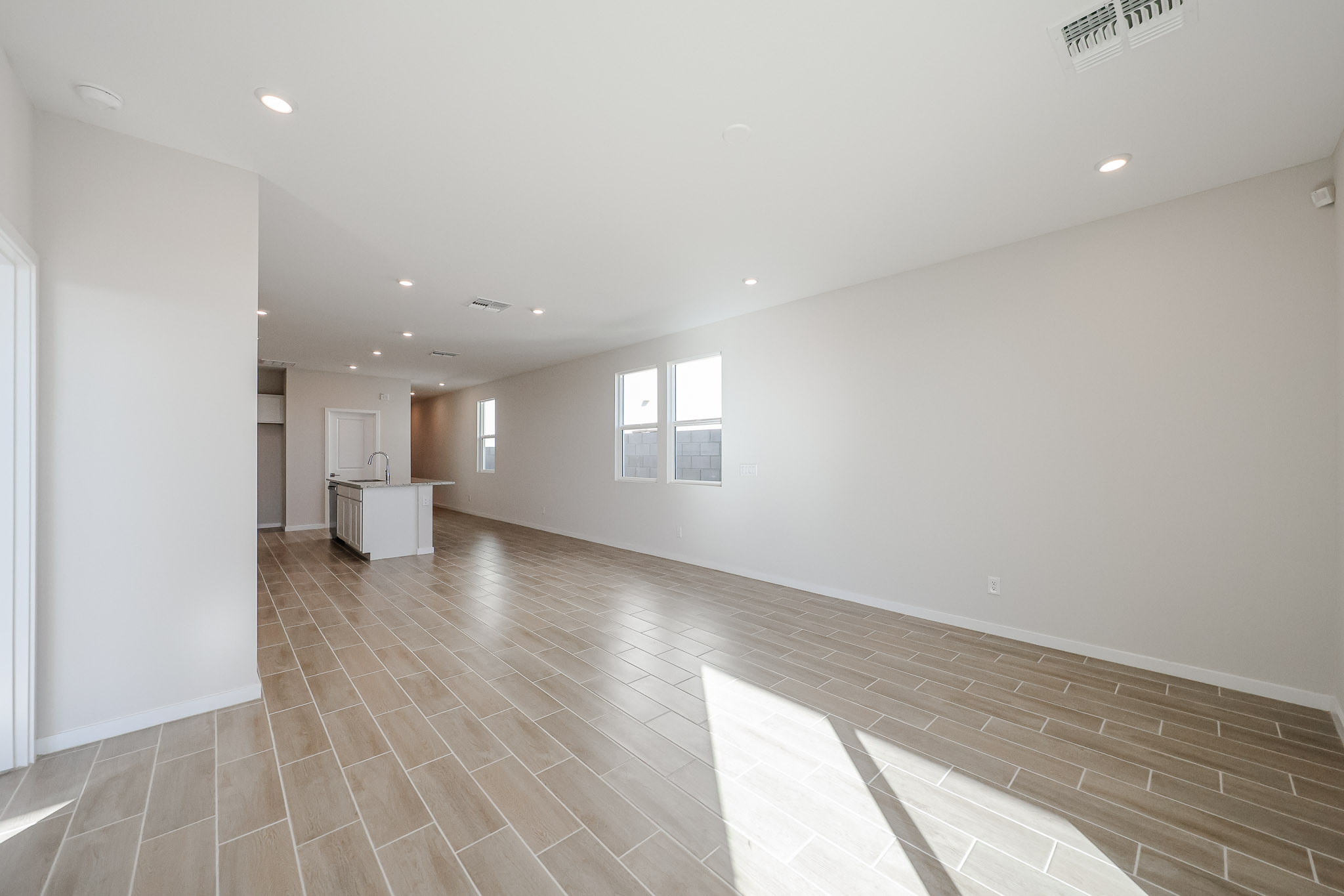 A large empty room with a wood floor and white walls.