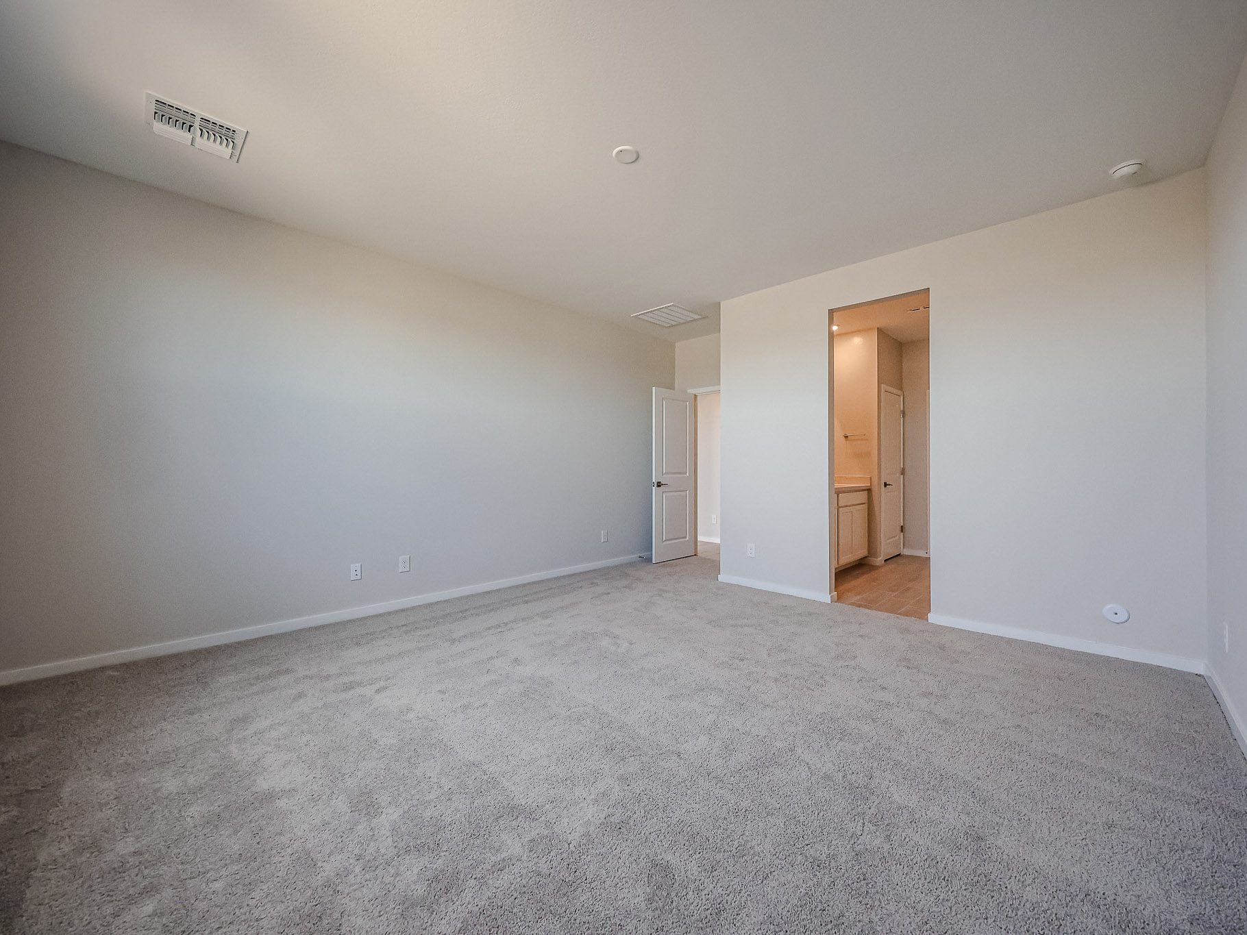 A room with a carpet and a door.