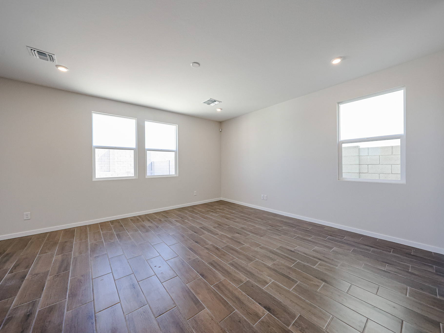 A room with windows and wood floor.