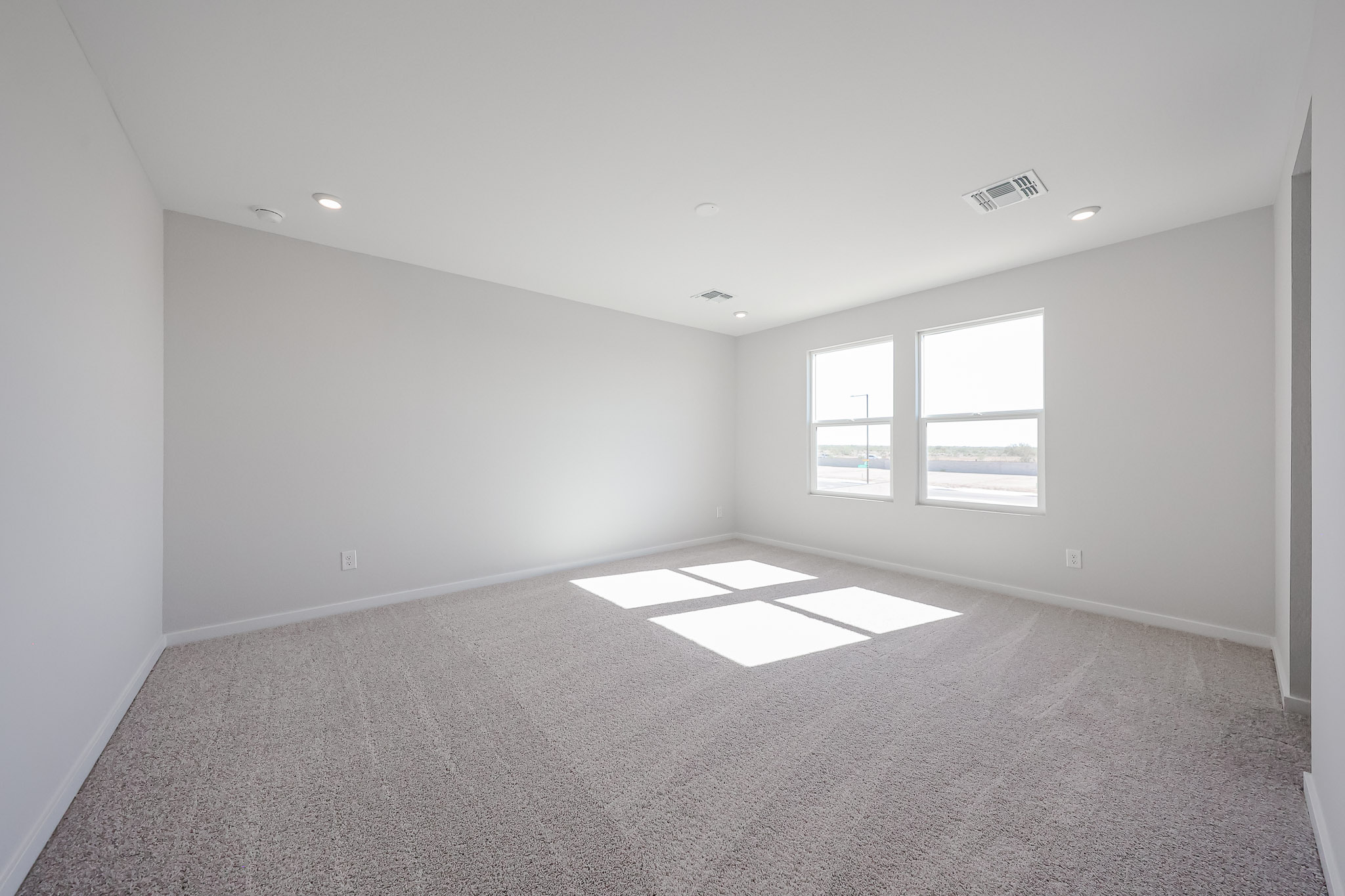 A room with a carpet and windows.