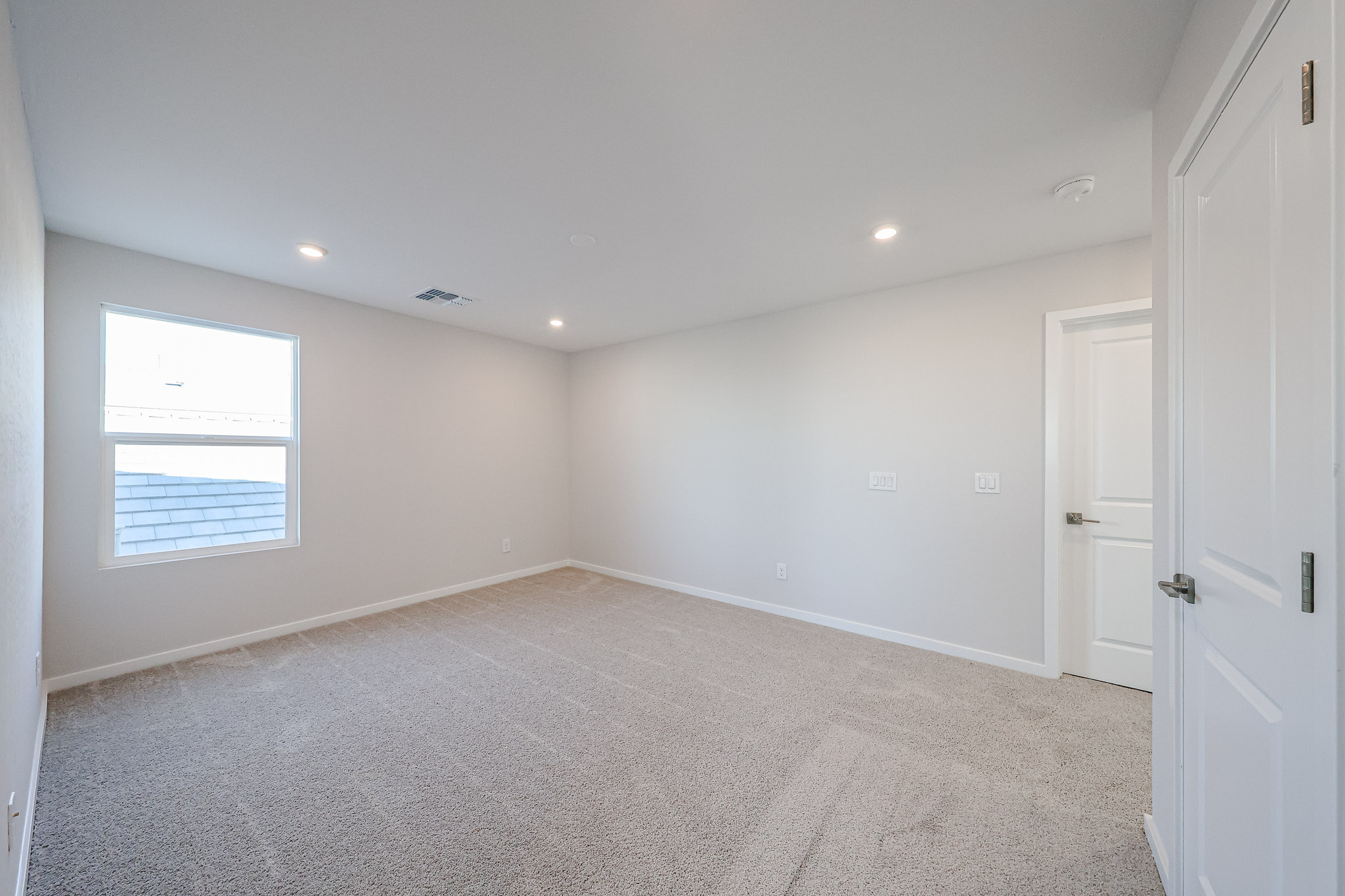 A room with white walls and a window.