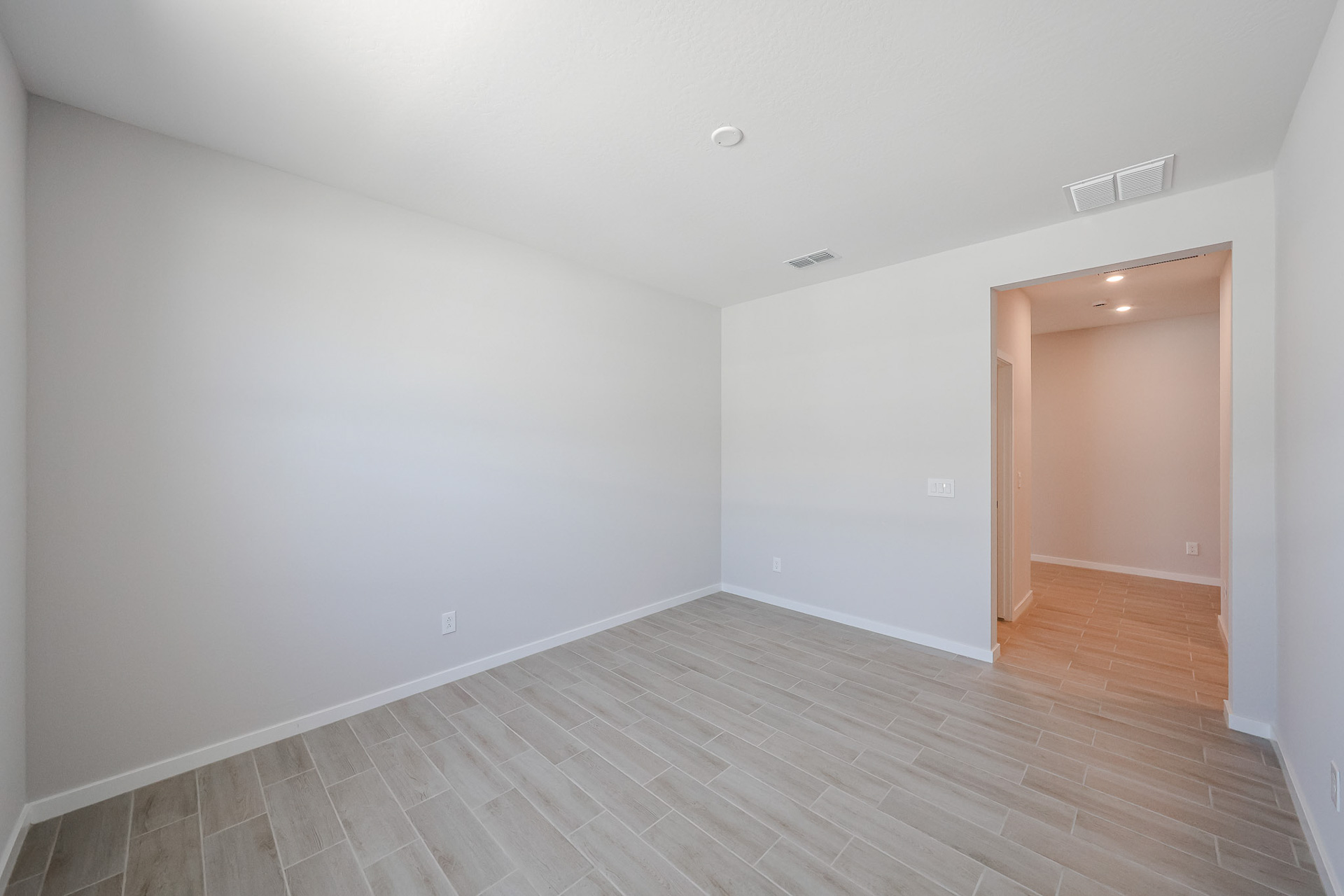 A room with a wood floor and a wood door.