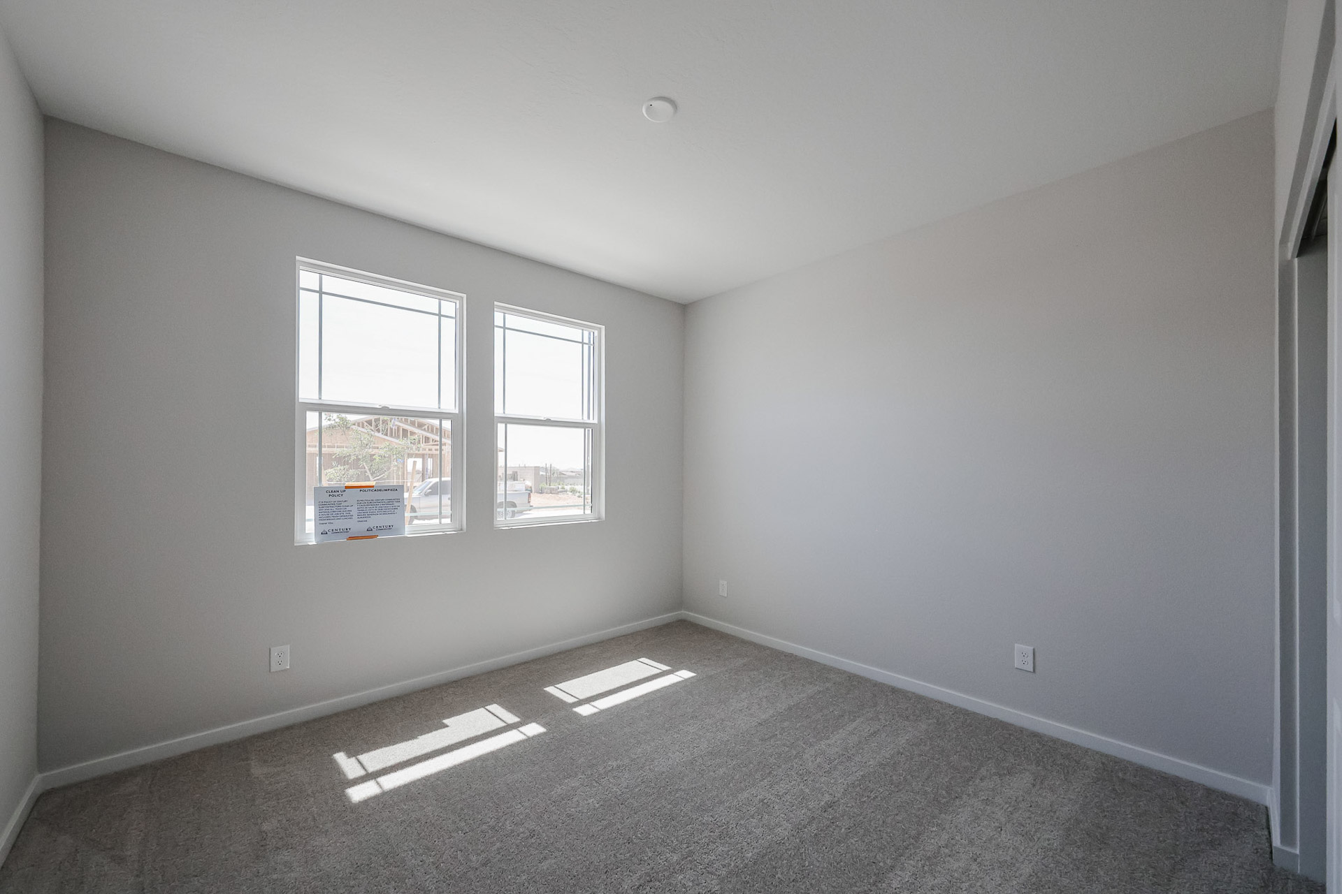A room with a carpet and a window.