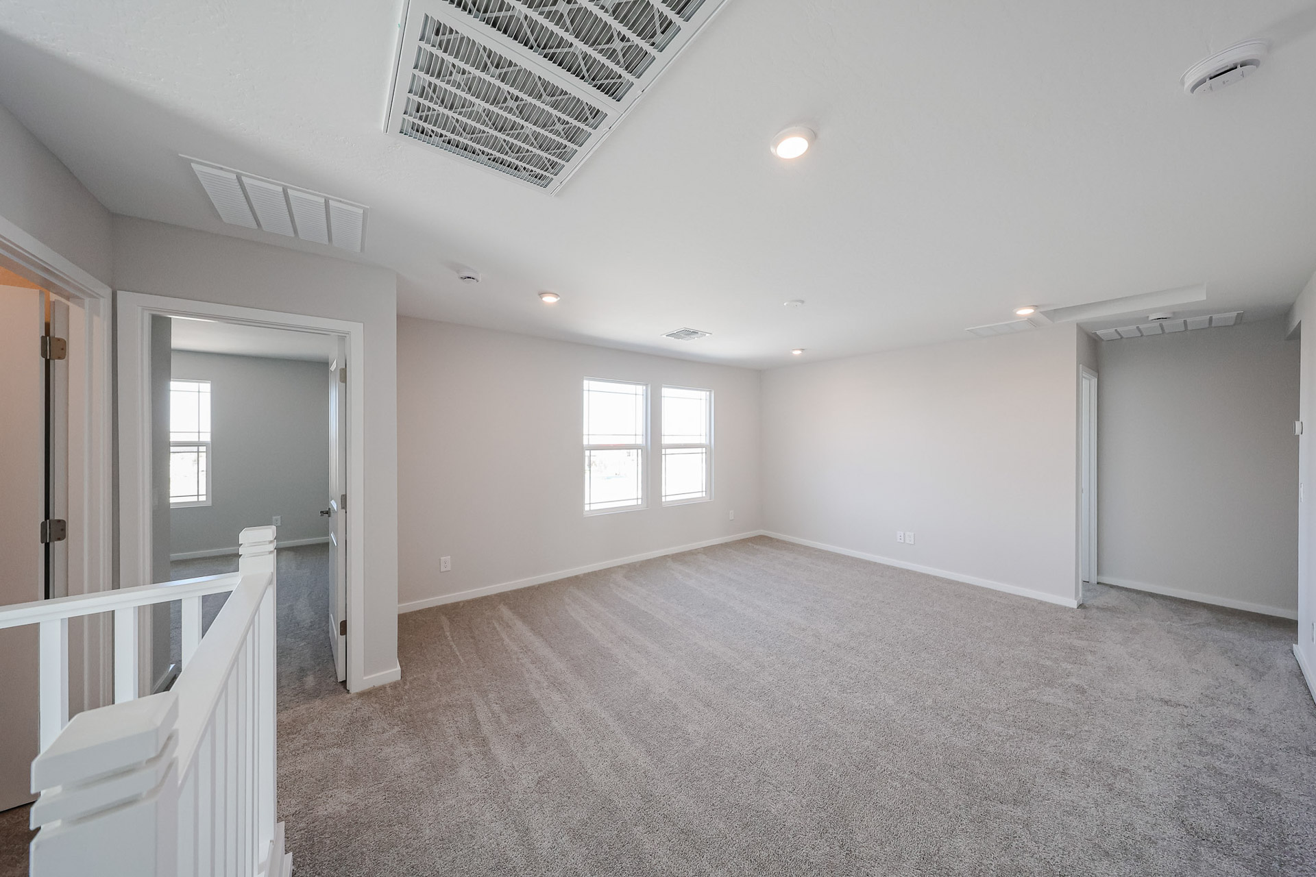 A room with white walls and a white railing.
