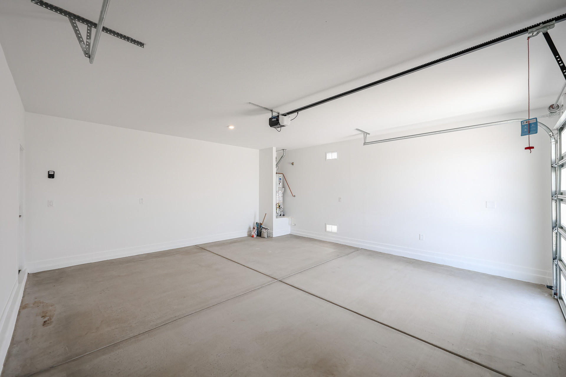 A room with a wood floor and a white wall with a light.