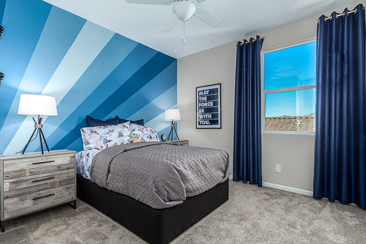A bedroom with a bed and blue curtains.