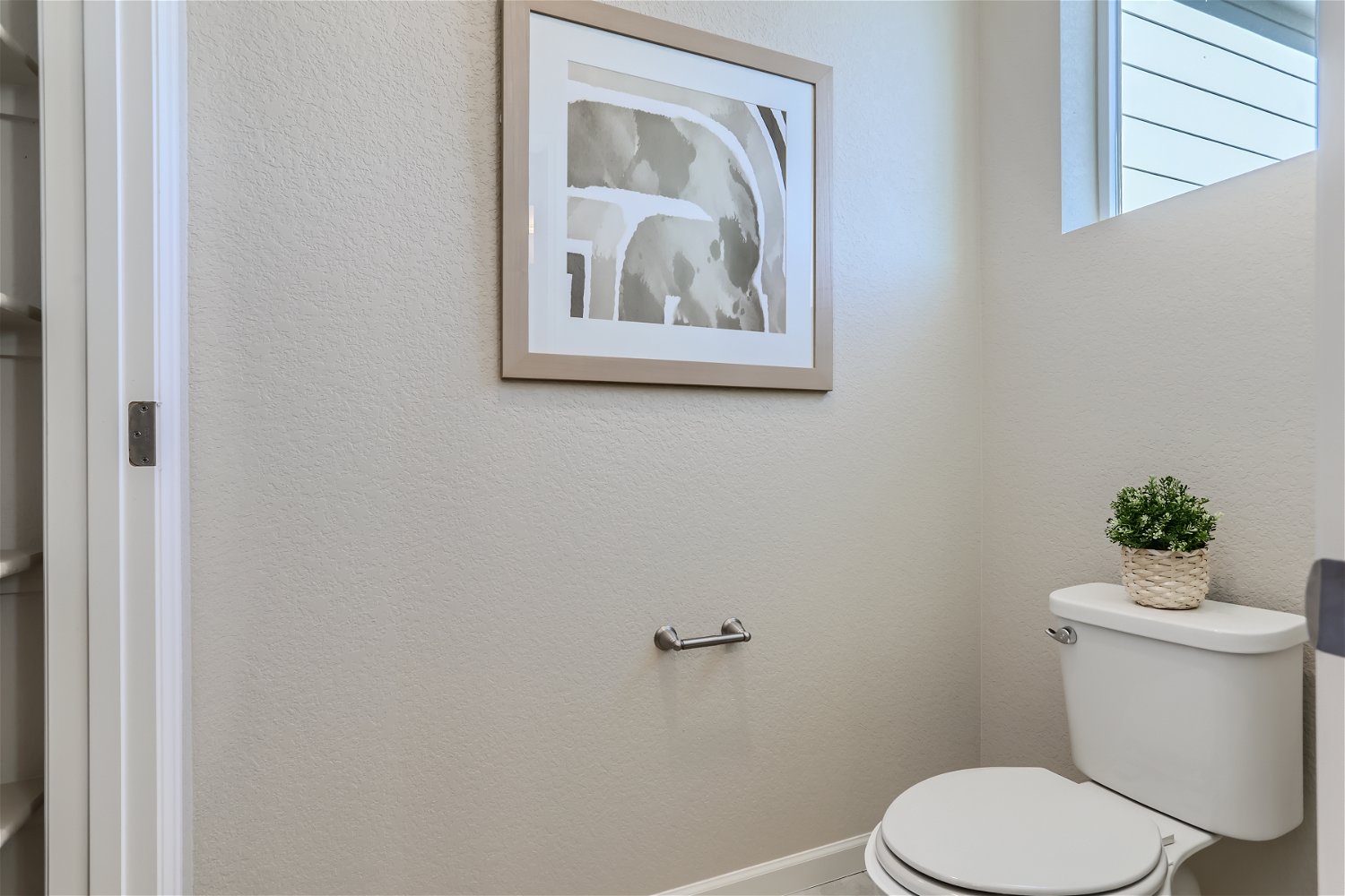A bathroom with a picture on the wall.
