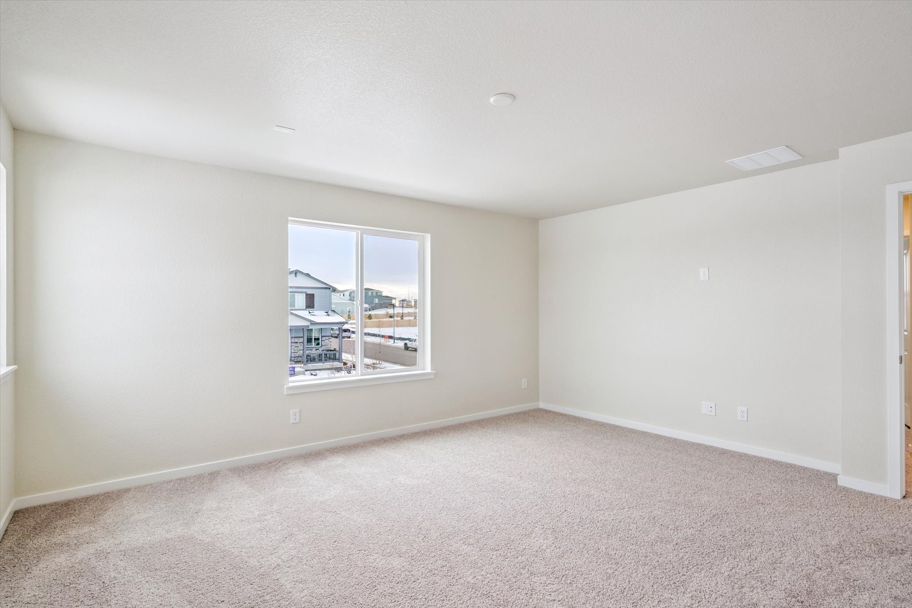 A room with a window and a carpet.