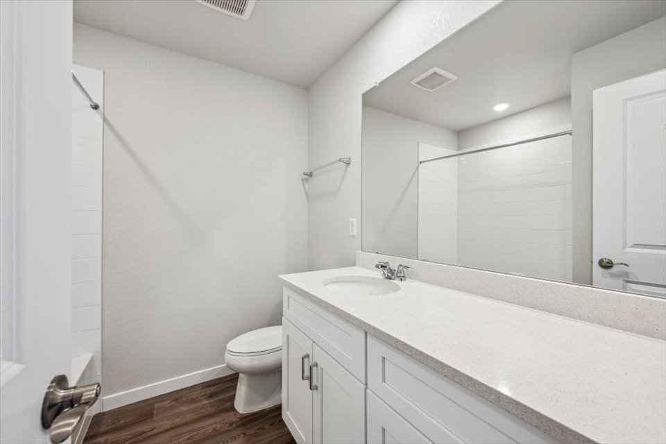 A bathroom with a tub sink and toilet.