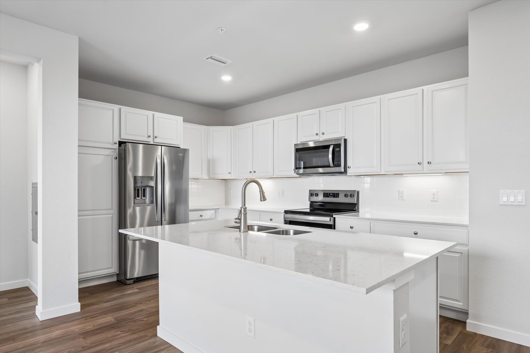 A kitchen with white cabinets.
