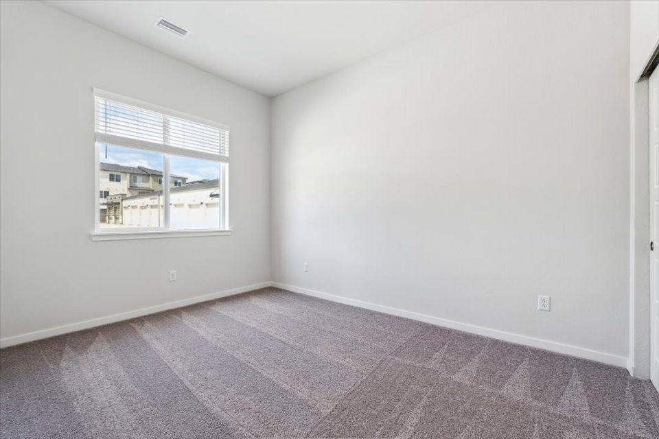 A room with a window and a rug.