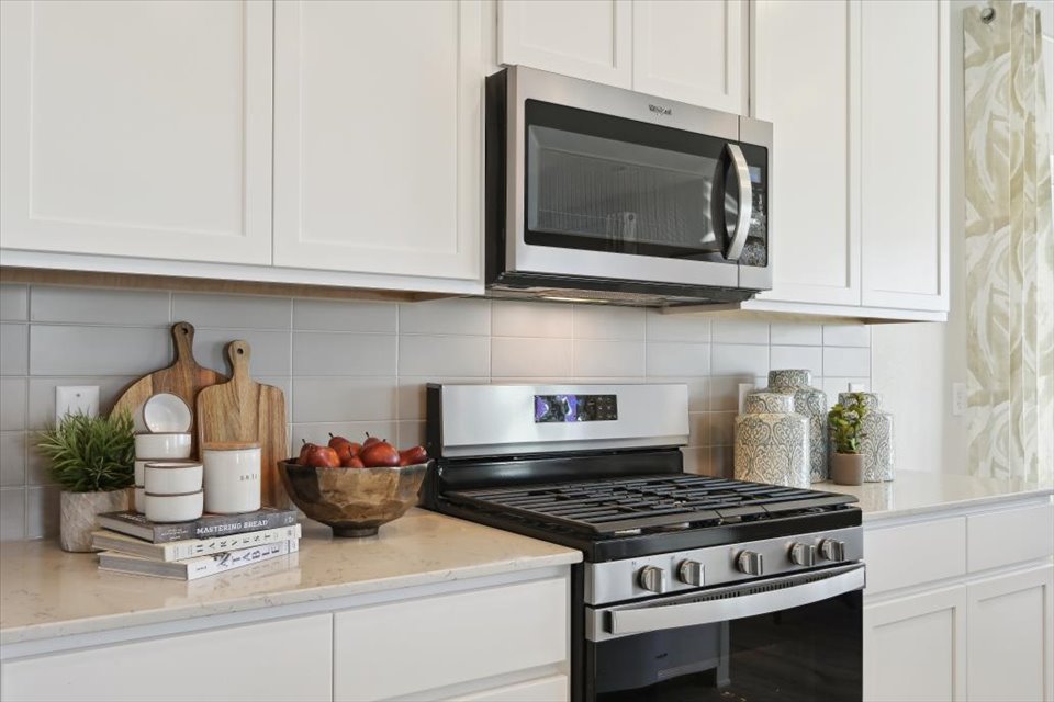A kitchen with white cabinets.