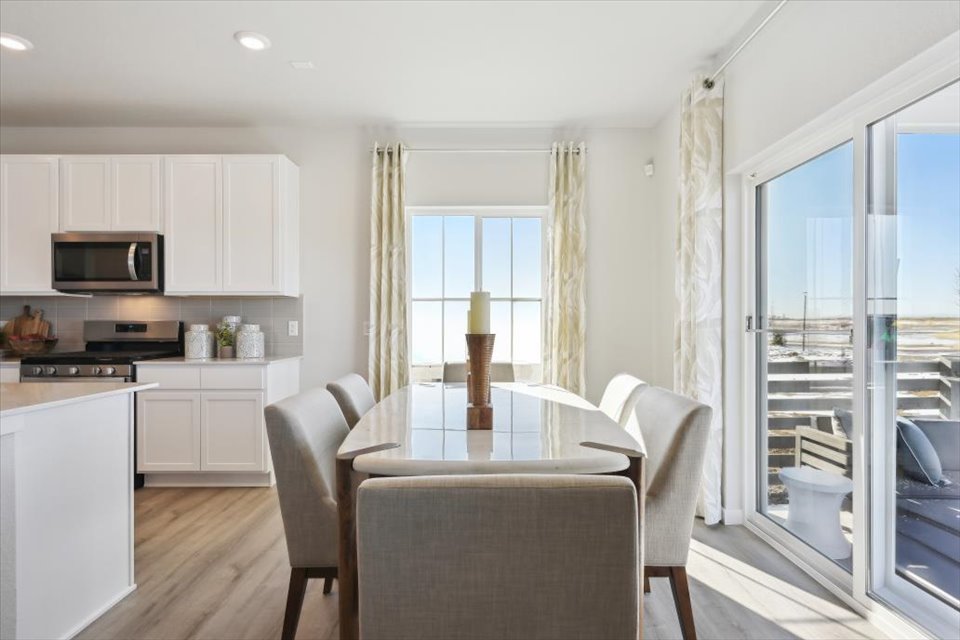 A kitchen with a dining table and chairs.