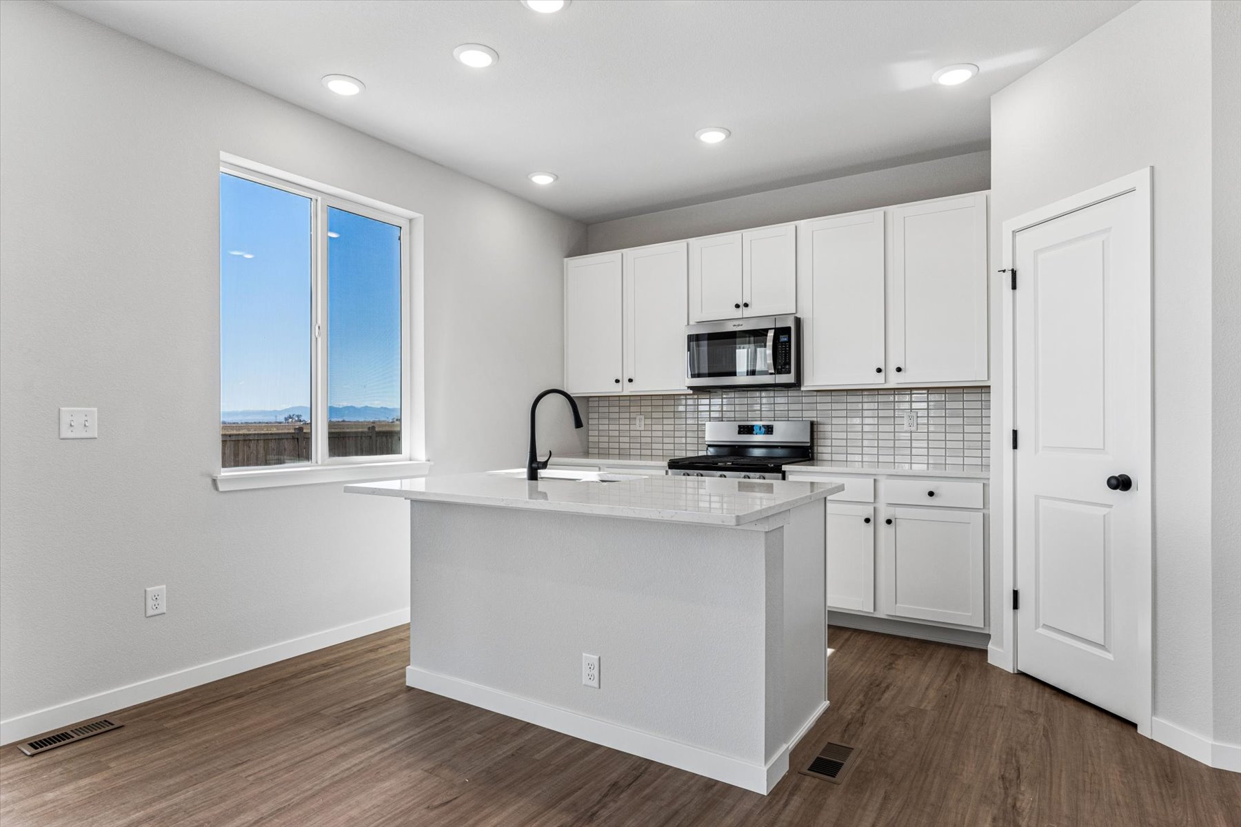 A kitchen with white cabinets.