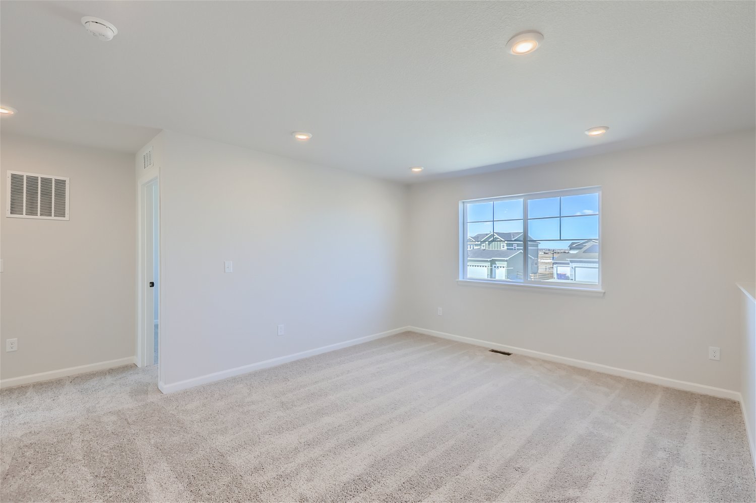 A room with a window and a carpet.