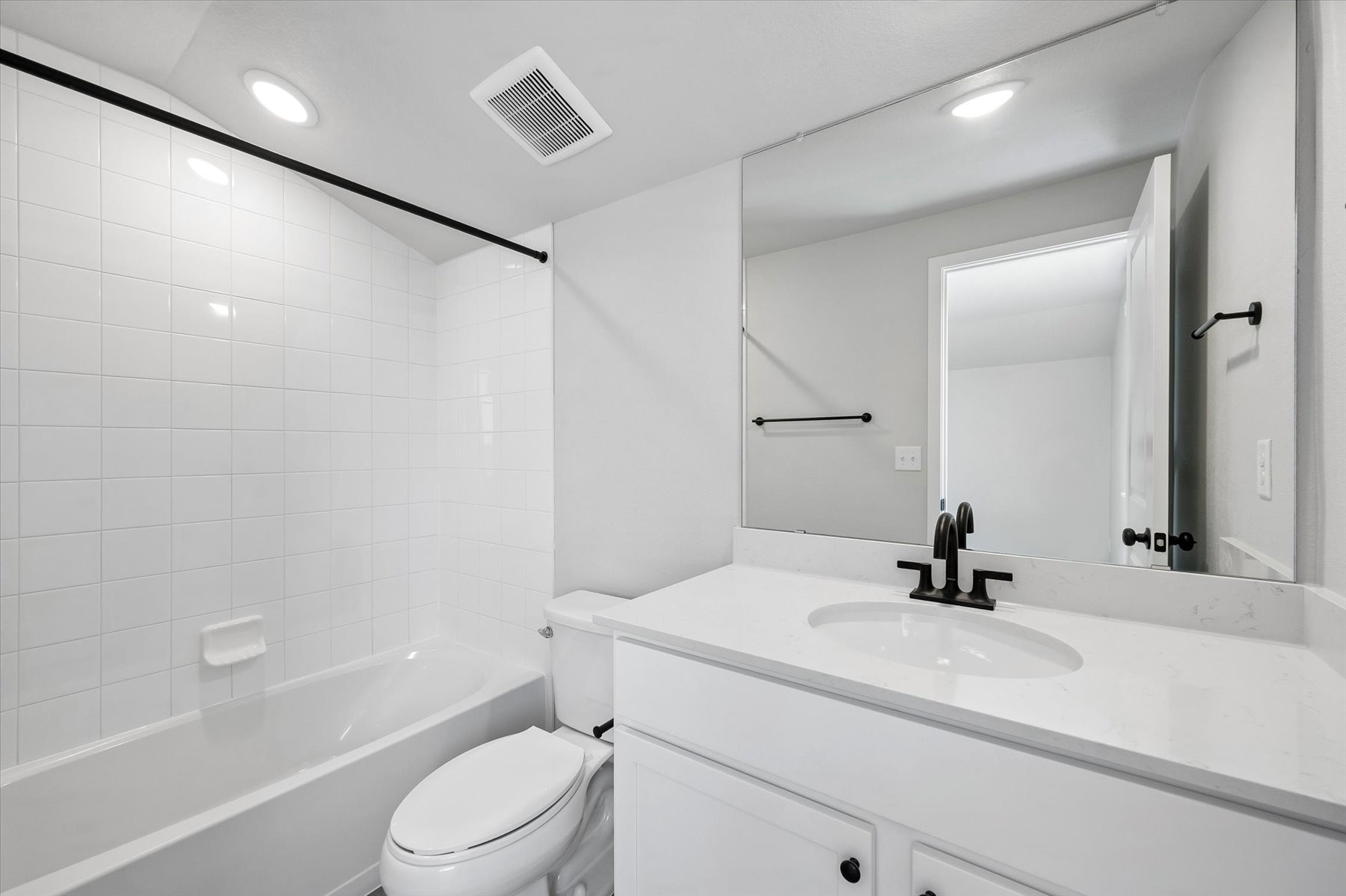 A bathroom with a tub sink and toilet.