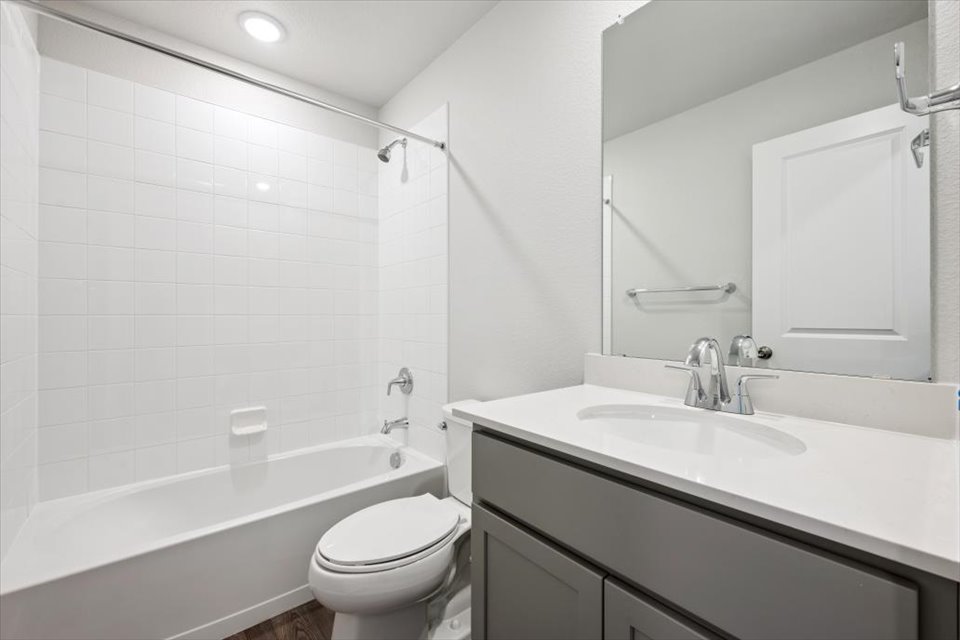 A bathroom with a tub sink and toilet.