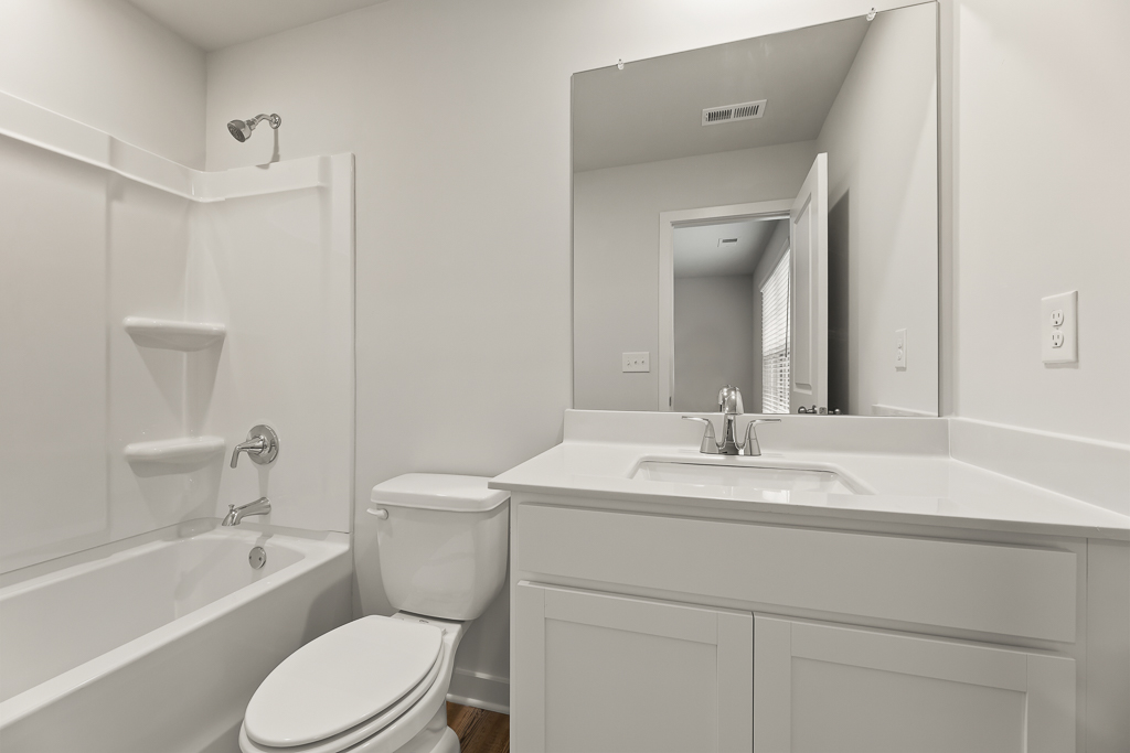 A bathroom with a tub sink and toilet.